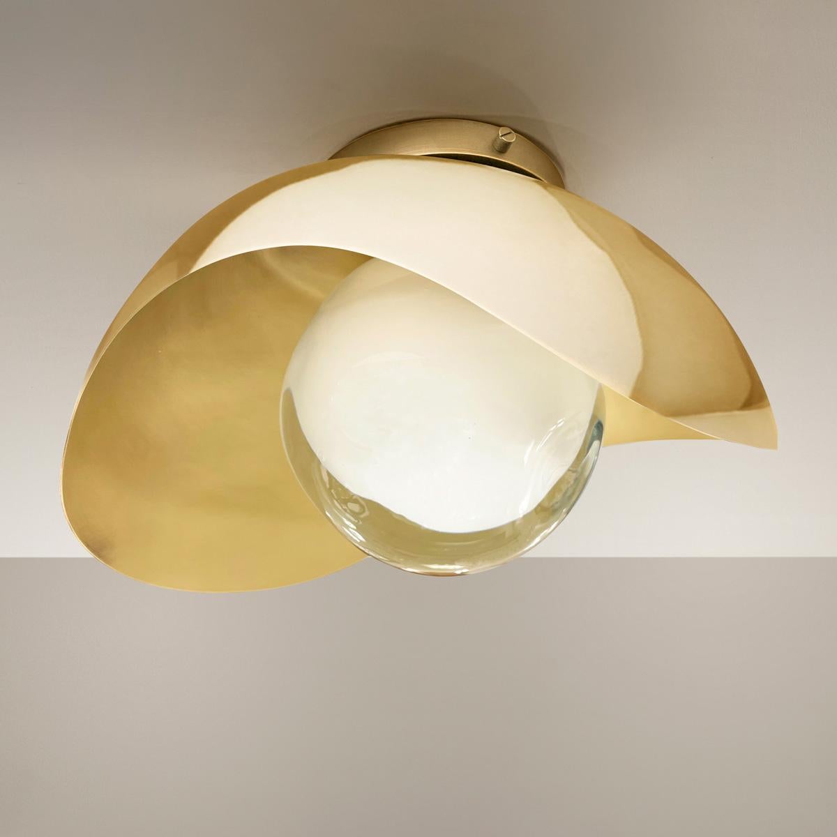 The Perla flushmount features an organic brass shell nestling our Sfera glass handblown in Tuscany. The first images show the fixture with a satin brass interior and polished brass exterior finish-subsequent pictures show it in a selection of