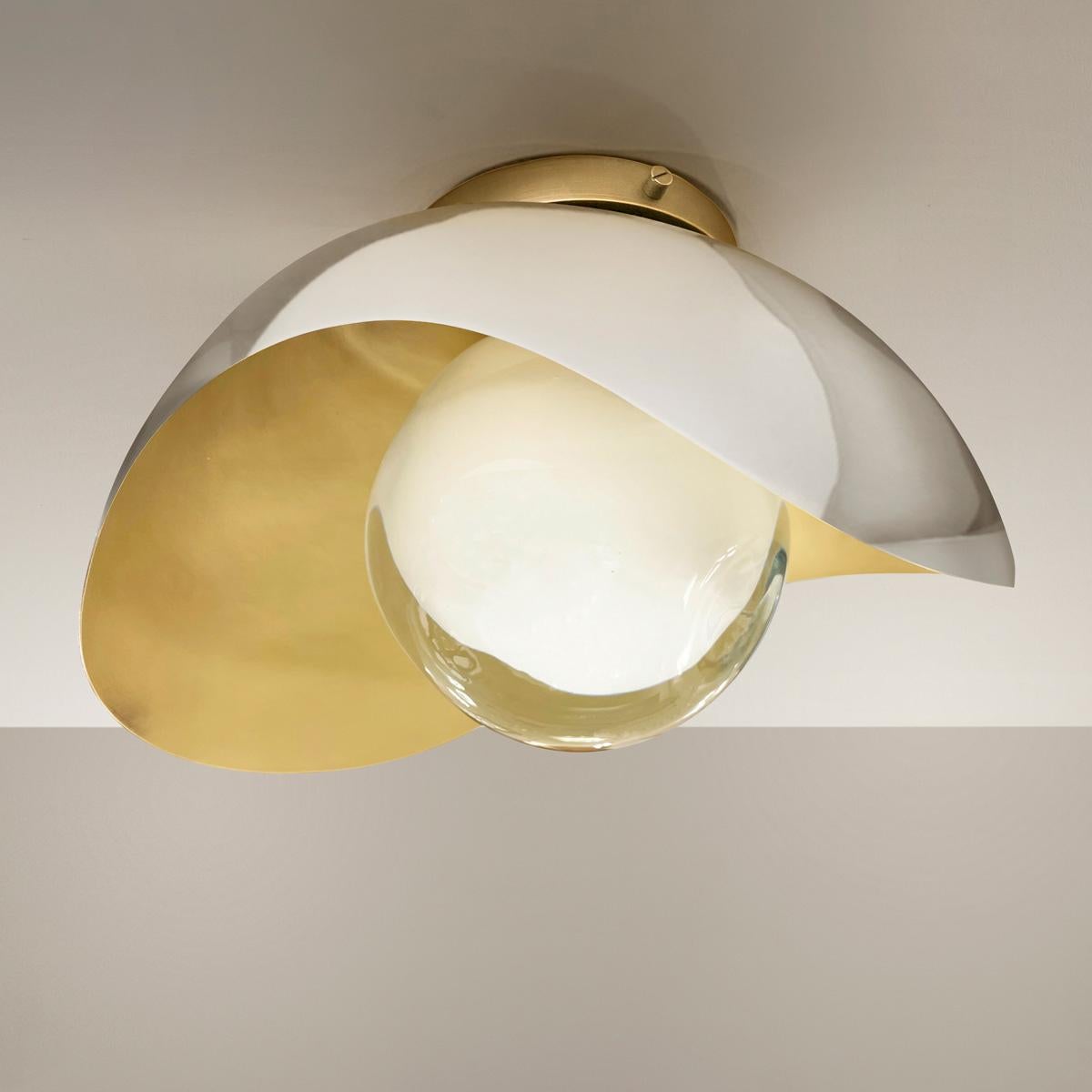 The Perla flushmount features an organic brass shell nestling our Sfera glass handblown in Tuscany. The first images show the fixture with a satin brass interior and polished nickel exterior finish-subsequent pictures show it in a selection of