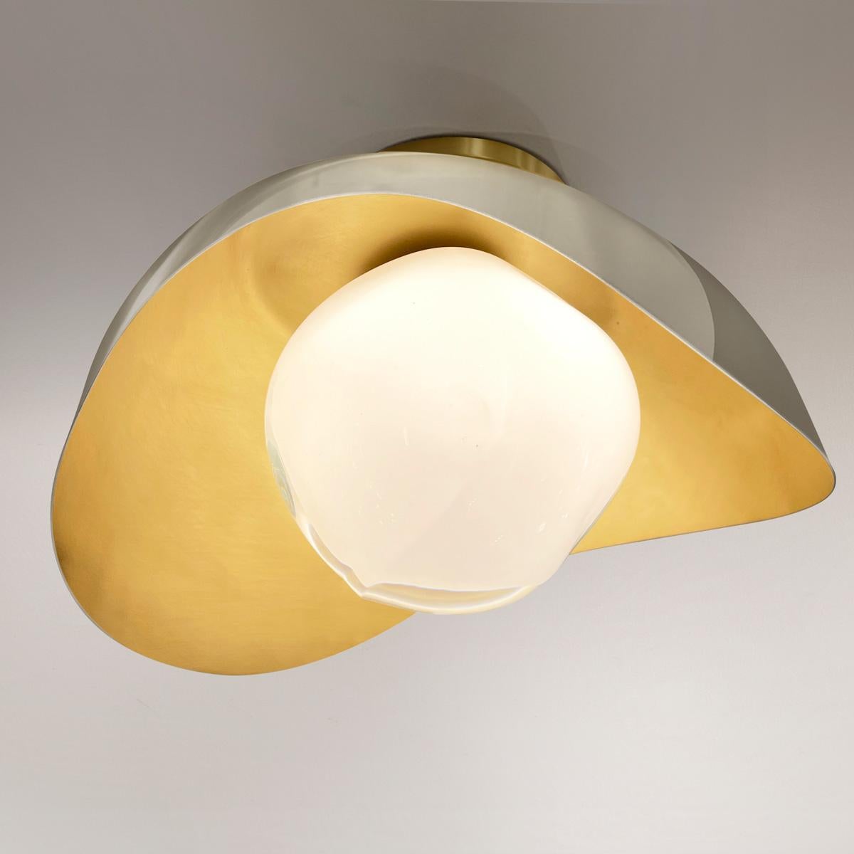 The Perla flushmount features an organic brass shell nestling our Sfera glass handblown in Tuscany. The first images show the fixture with a satin brass interior and polished nickel exterior finish-subsequent pictures show it in a selection of