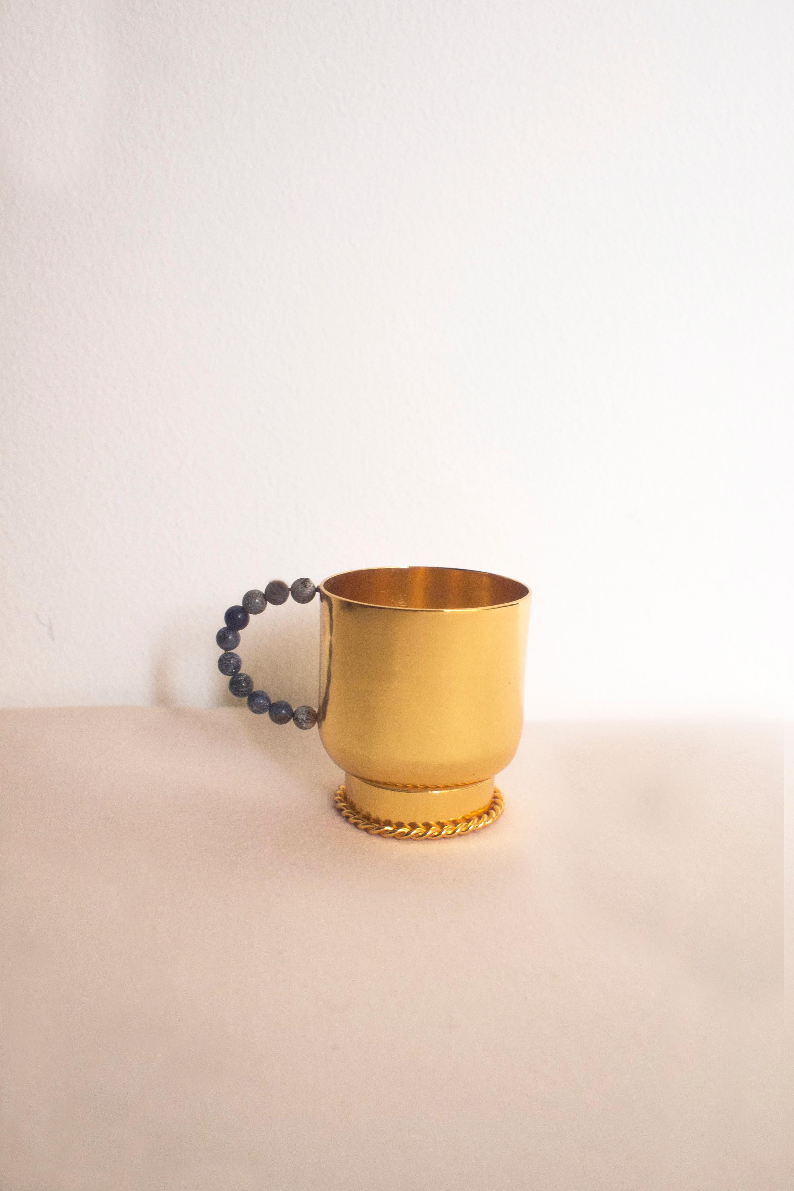 Elevate your daily tea or coffee ritual with our exquisite perline torch cup. The plated brass cup is handcrafted in Italy using sheet turning techniques. The handle, adorned with a row of lapiz lazuli stones, introduces a touch of jewelry-inspired