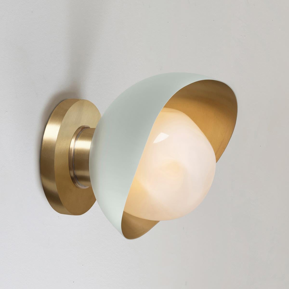The Perla Mini wall light is the smallest member of the Perla collection featuring an organic brass shell nestling our Sfera glass handblown in Murano. See the Perla and Perla Grande for larger models.

The primary images show it in Lerici Acqua and
