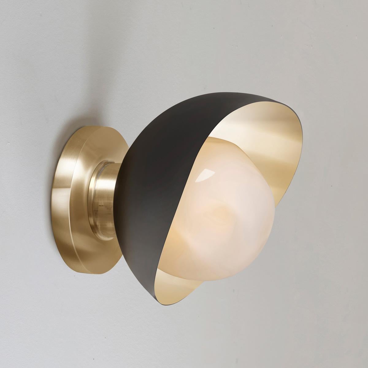 The Perla Mini wall light is the smallest member of the Perla collection featuring an organic brass shell nestling our Sfera glass handblown in Murano. See the Perla and Perla Grande for larger models.

The primary images shows it in black and