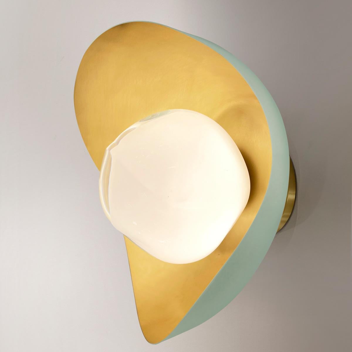 The Perla wall light features an organic brass shell nestling our Sfera glass handblown in Tuscany. The first images show the fixture with a satin brass interior and Lerici Acqua exterior finish-subsequent pictures show it in a selection of