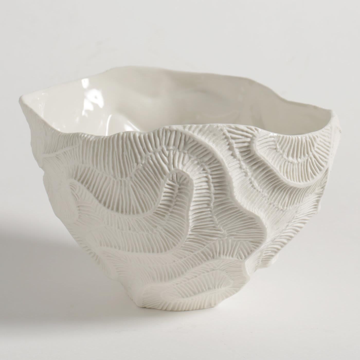 Fossils of madrepore inspire the minute texture decorating this exquisite bowl of the Fossilia collection. A meticulously crafted mold and the use of precious unglazed porcelain, or 