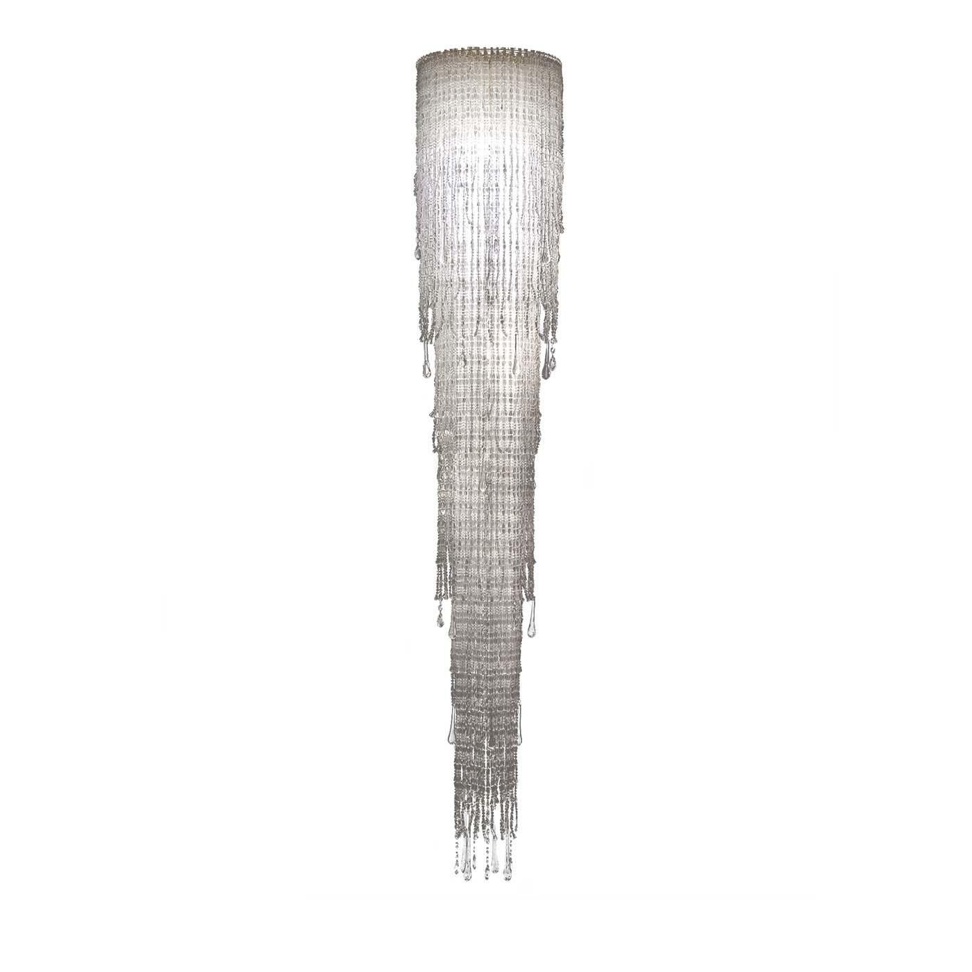 A stunning cascade handmade of strands of irregularly shaped, transparent beads marks the design of this splendid suspension lamp. Its alluring design, enriched by crystal elements, will effortlessly stand out in the most sophisticated decors.