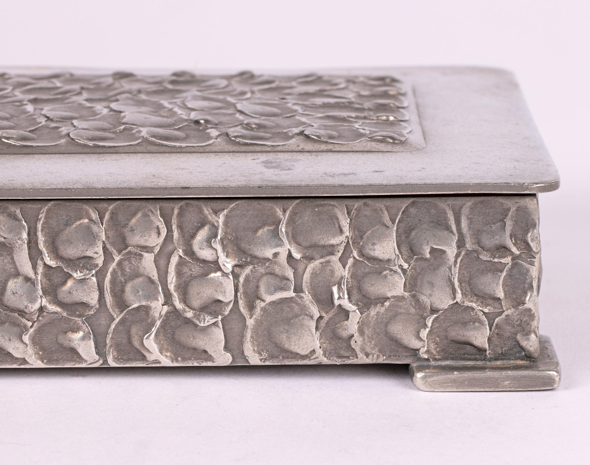A very stylish Norwegian Art Deco pewter cigar or cigarette box with brutalist styling made by Perletinn and dating from around 1930. The box is of shallow rectangular shape mounted and raised on four corner triangular shaped flat feet. The hinged