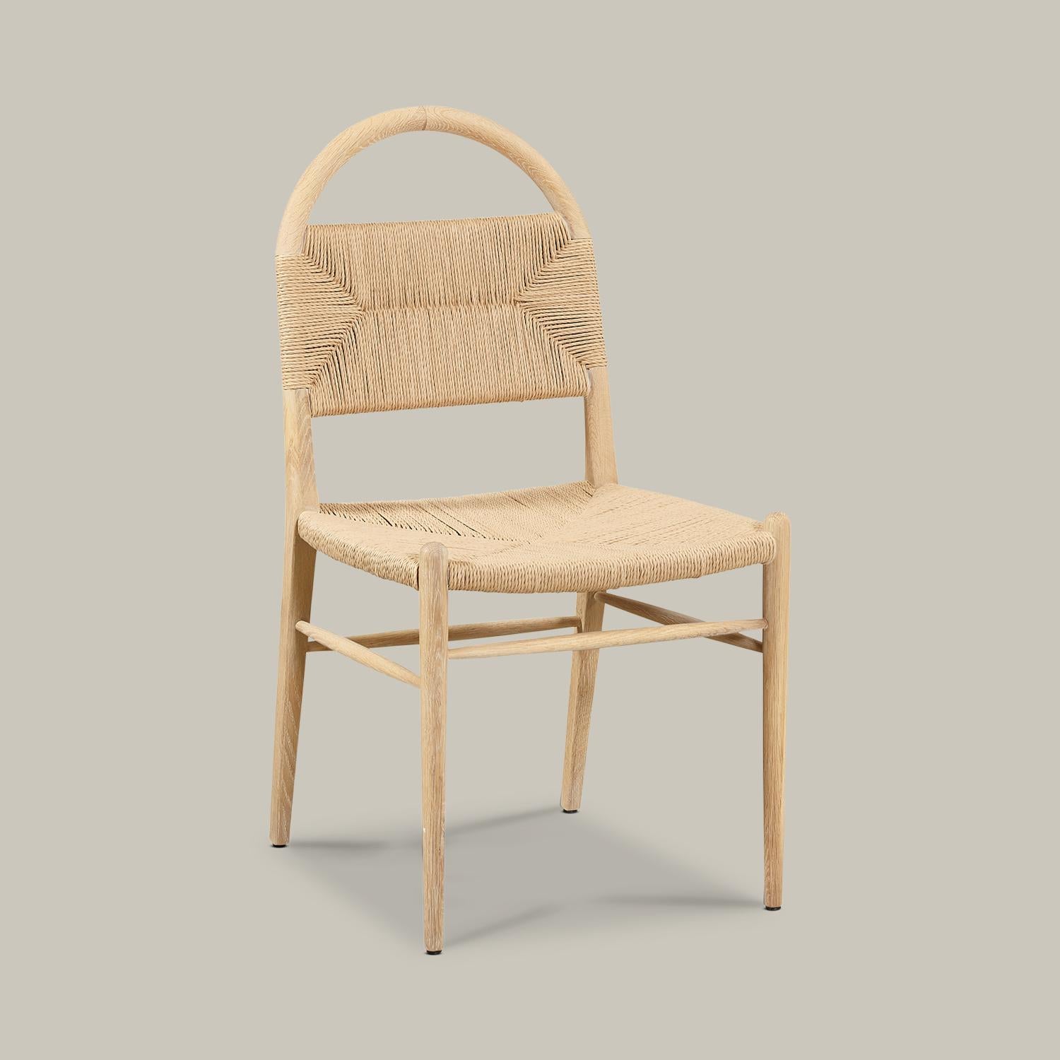 A solid wood arched frame threads through a woven rush seat with arms and backrest to form this well-proportioned, minimalist chair for dining, desk, vanity or an accent in any room. Handmade by artisans in Vietnam, this piece is available in