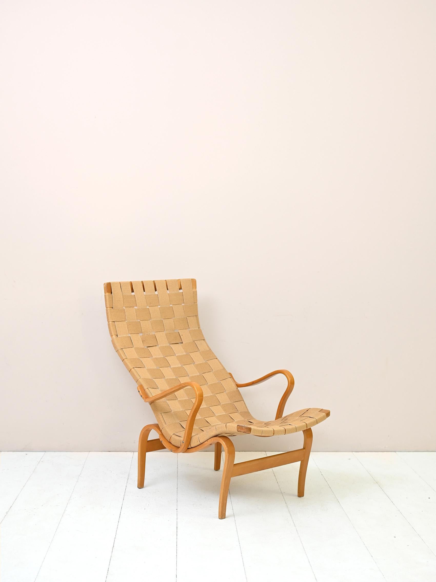 Iconic 'Pernilla' armchair designed by Bruno Mathsson for Karl Mathsson AB in Värnamo, Sweden in the 1940s.

The frame is made of birch wood and the seat of canvas with crossed straps.

Good condition. The color of the canvas of the armchair is