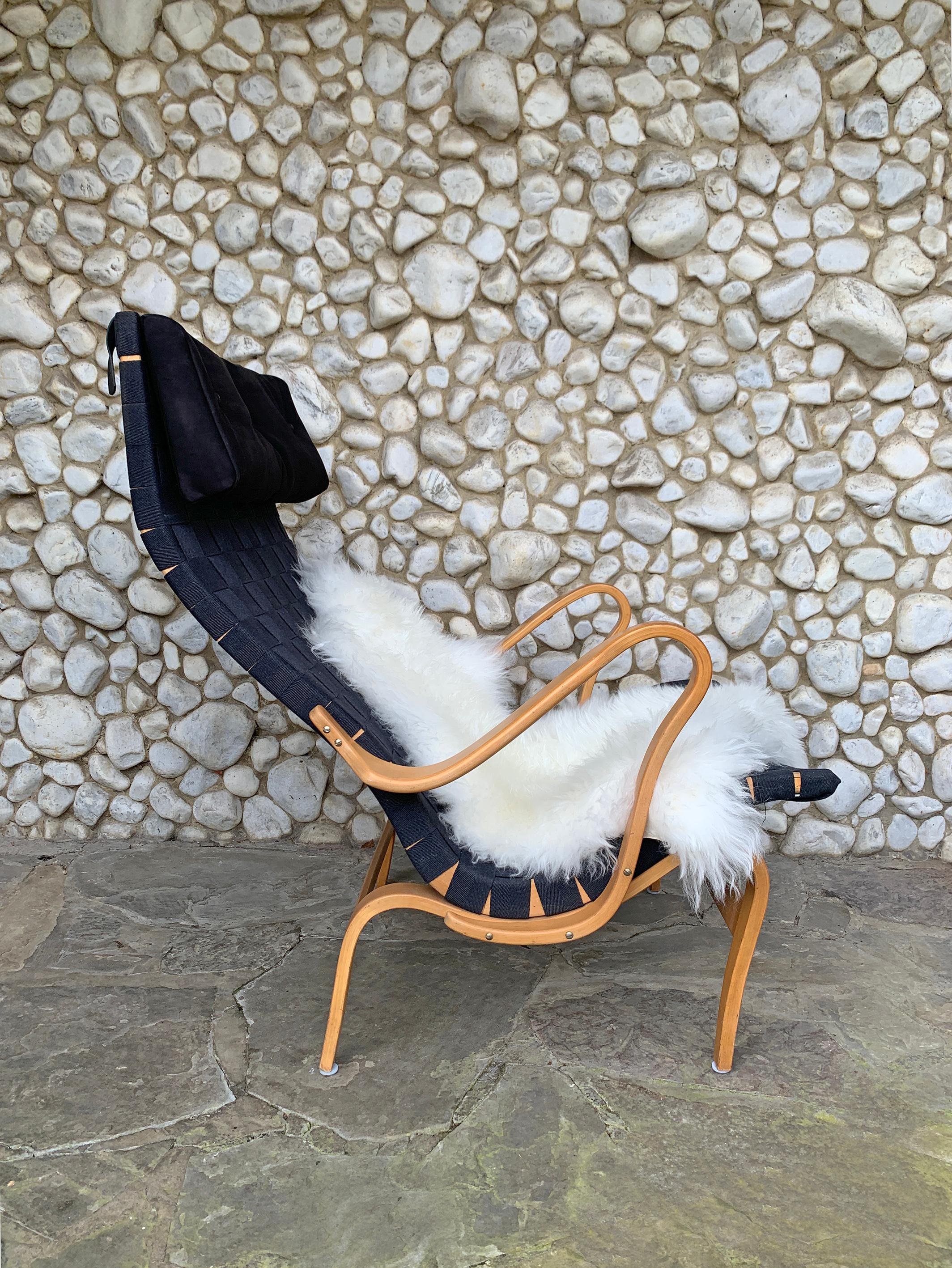 Pernilla Lounge Sessel.  Die Sitzfläche besteht aus gewebtem Gurtband, das zwischen einem Rahmen aus dampfgebogener Buche gespannt ist. Dieser Stuhl ist mit schwarzem Original-Leinwandgewebe ausgestattet, was sehr selten ist.

Im Jahr 1944 entwarf
