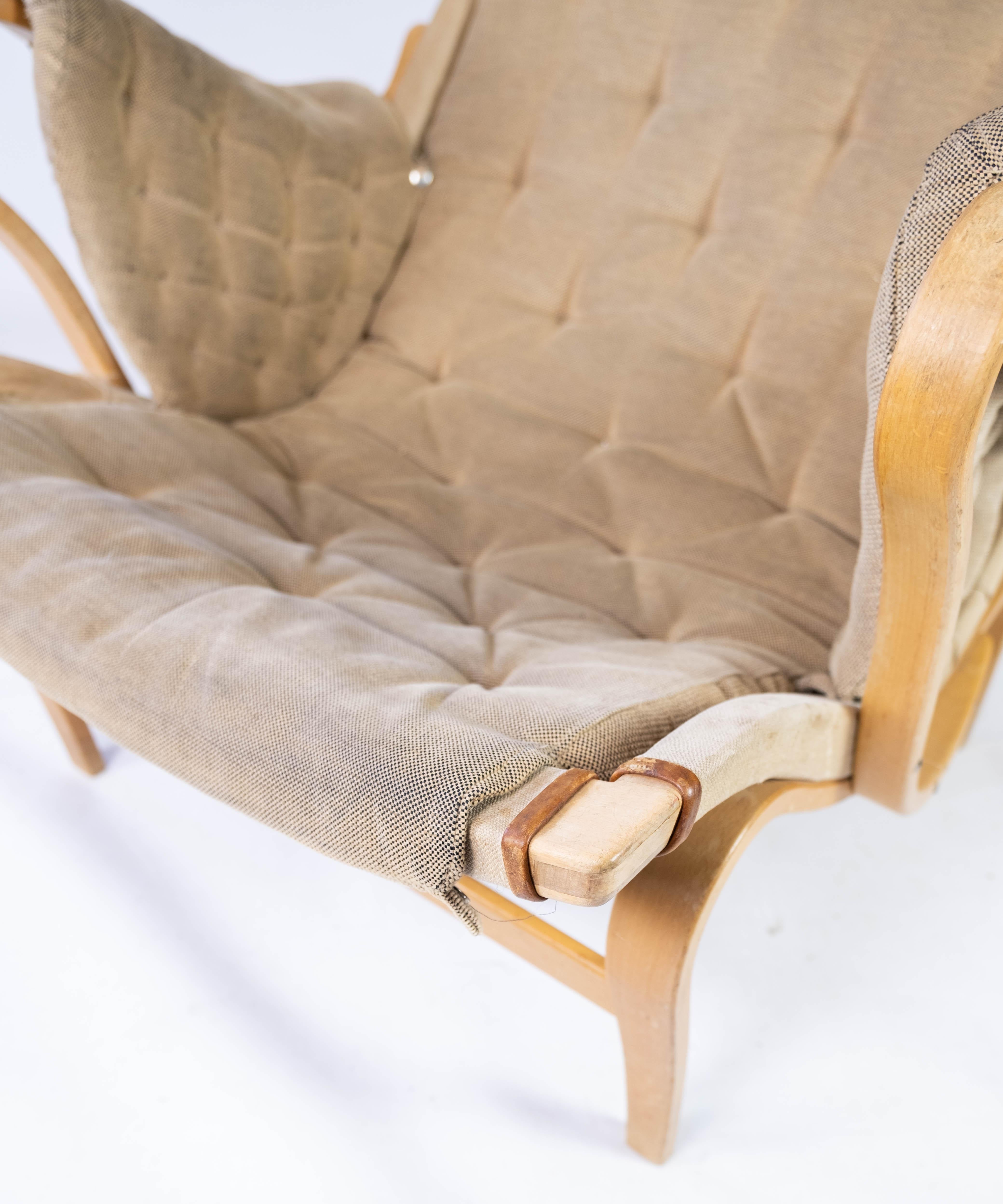 Le fauteuil Pernilla, conçu par Bruno Mathsson et fabriqué par Dux dans les années 1960, représente une pièce du mobilier scandinave. Cette chaise, avec son cadre en bois courbé caractéristique et son assise de forme organique, dégage une élégance