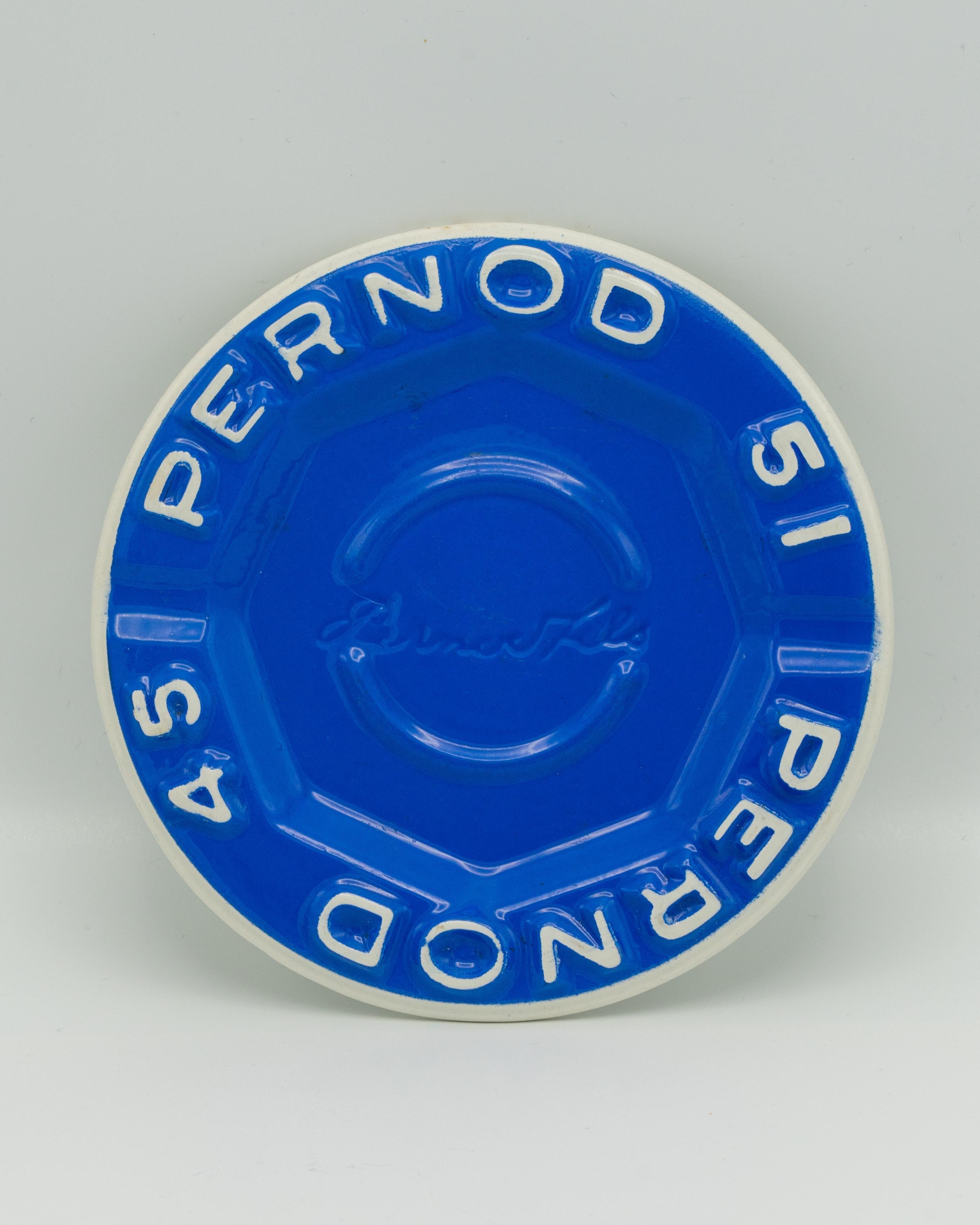 This striking cobalt blue ashtray or vide-poche (pocket emptier) is an iconic piece of French advertising history, featuring raised lettering for Pernod 45 and Pernod 51, two famous variations of the classic Pernod et fils pastis. The bold relief