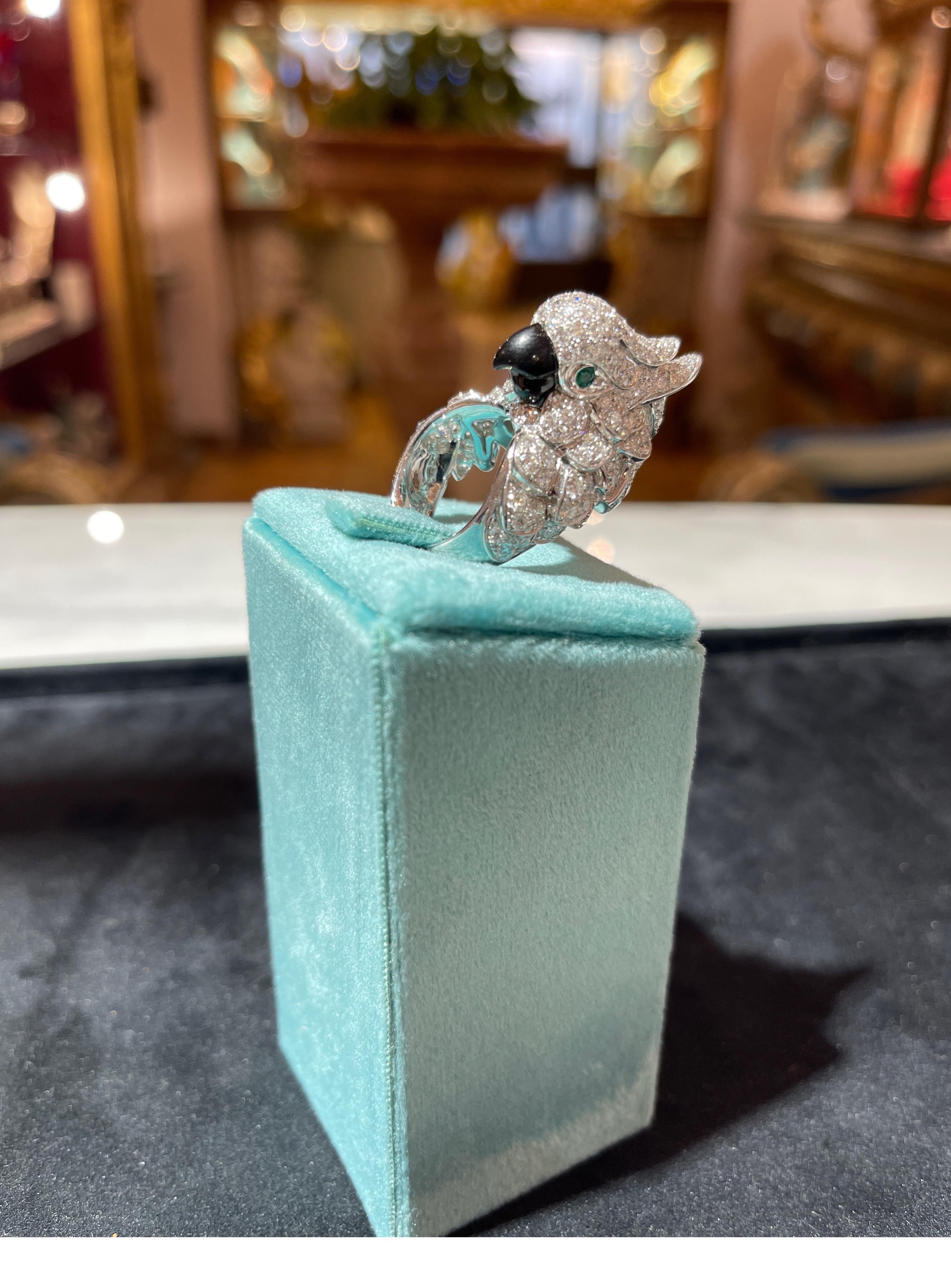 Marvelous parrot-shaped ring in 18ct white gold treaded with diamonds (4.07ct) and with two emerald eyes (0.10ct) the beak is a piece of carved onyx