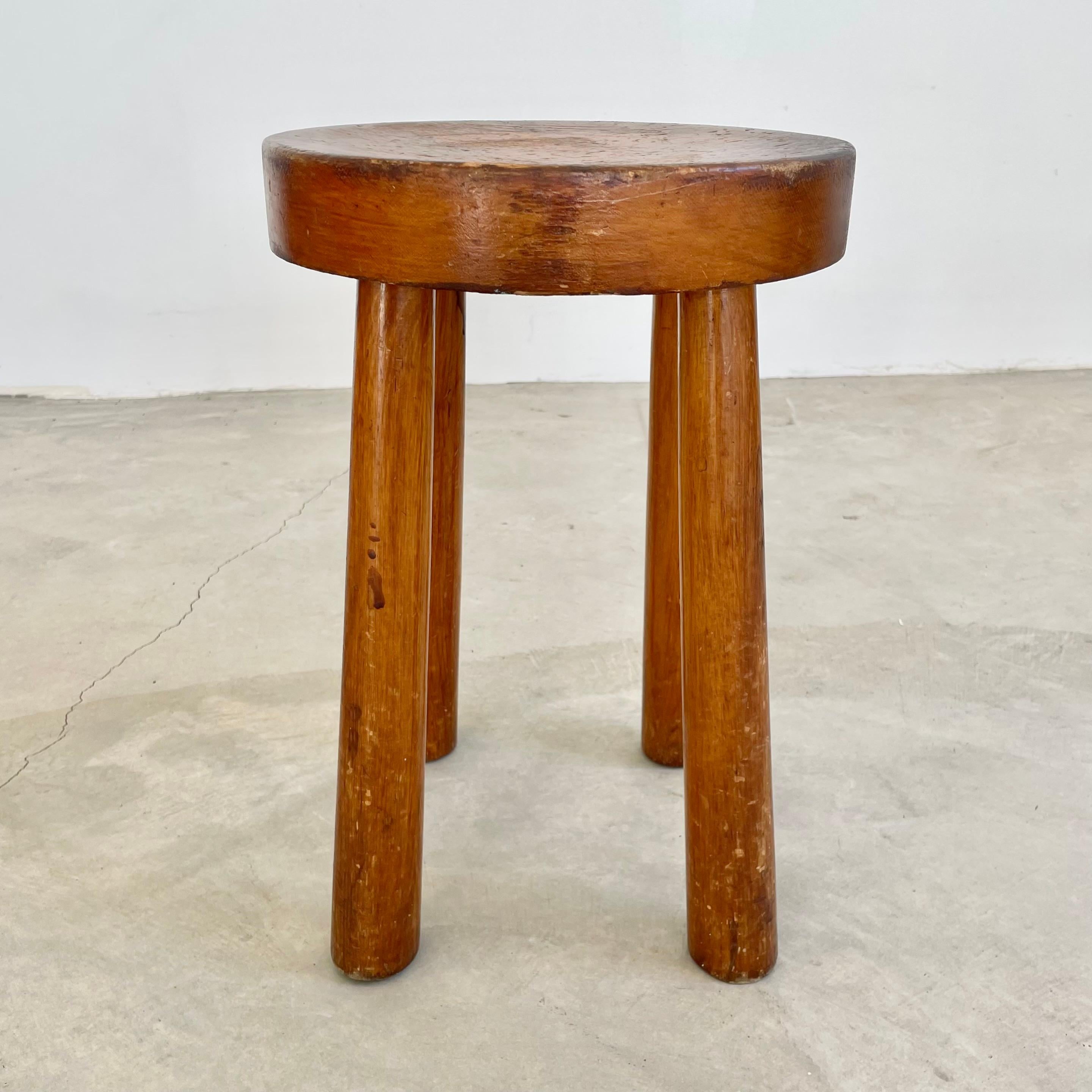 Beautiful Perriand style, 4 legged stool made in France, circa 1960s. Substantial and chunky round seat with four sturdy club legs that taper out at the bottom. Perfect patina and age have made this stool a perfect example of brutalist stools.