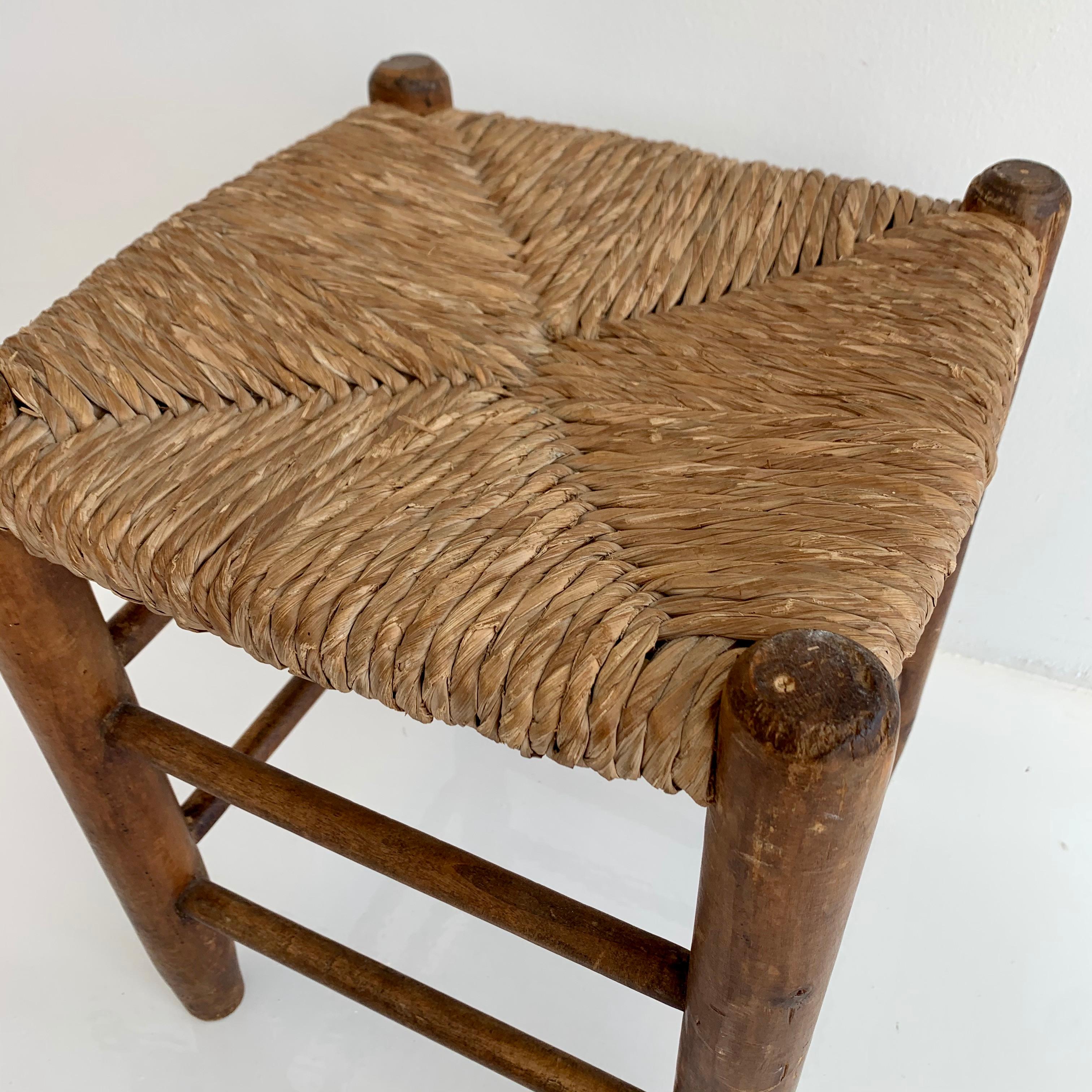 Handsome wood stool from France in the style of Charlotte Perriand. Oak four post frame with straw seat and wooden dowels. No hardware or screws. Great vintage stool.