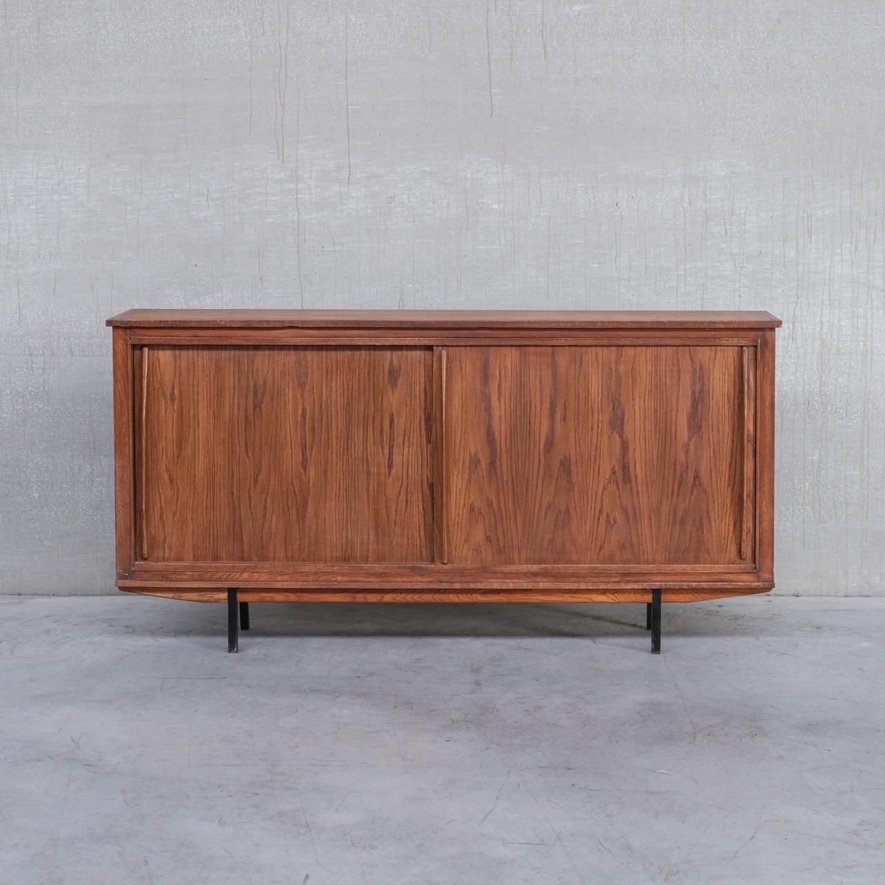 A good looking mid-20th sideboard. 

France, c1960s. 

In the style of Charlotte Perriand but unknown maker. 

Raised on iron legs. 

One shelf internally. 

Generally good condition, some scuffs and wear commensurate with age.