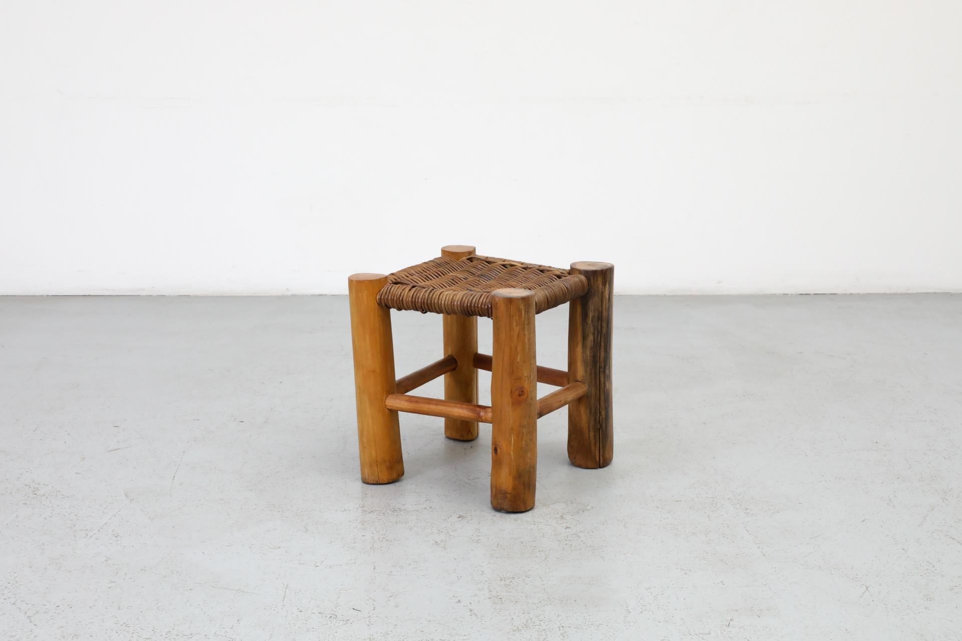 Charlotte Perriand inspired primitive wooden stool with woven rush top and thick round legs. This piece has a great blend of artistry and skill and a significant presence / wabi-sabi. In original condition with visible wear and patina. Wear is