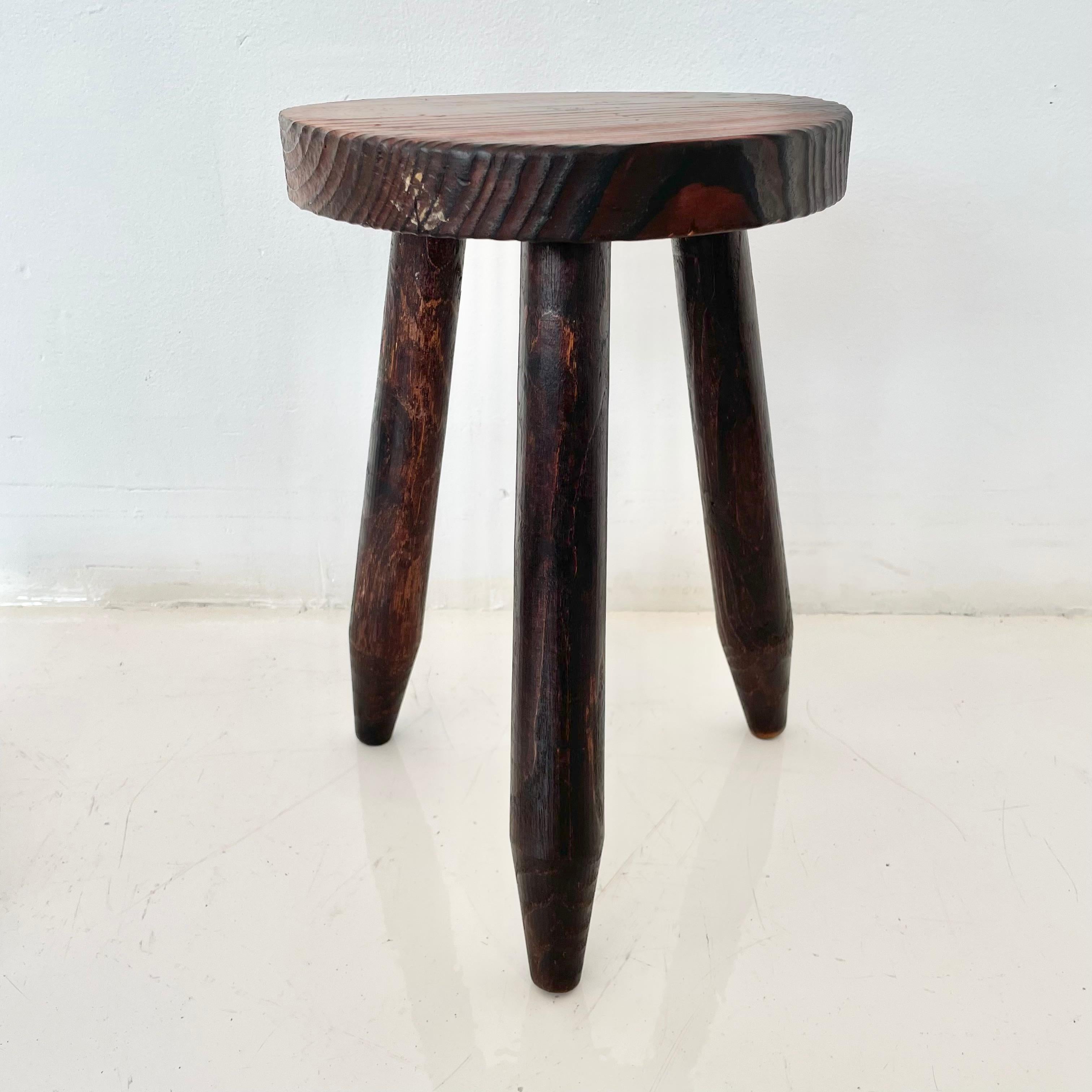 Fantastic wood stool from France in the style of Charlotte Perriand. Made in the 1960s with three tapered legs. No hardware. Beautiful wood grain and texture as well as a deep burgundy color to wood. Good vintage condition.
 