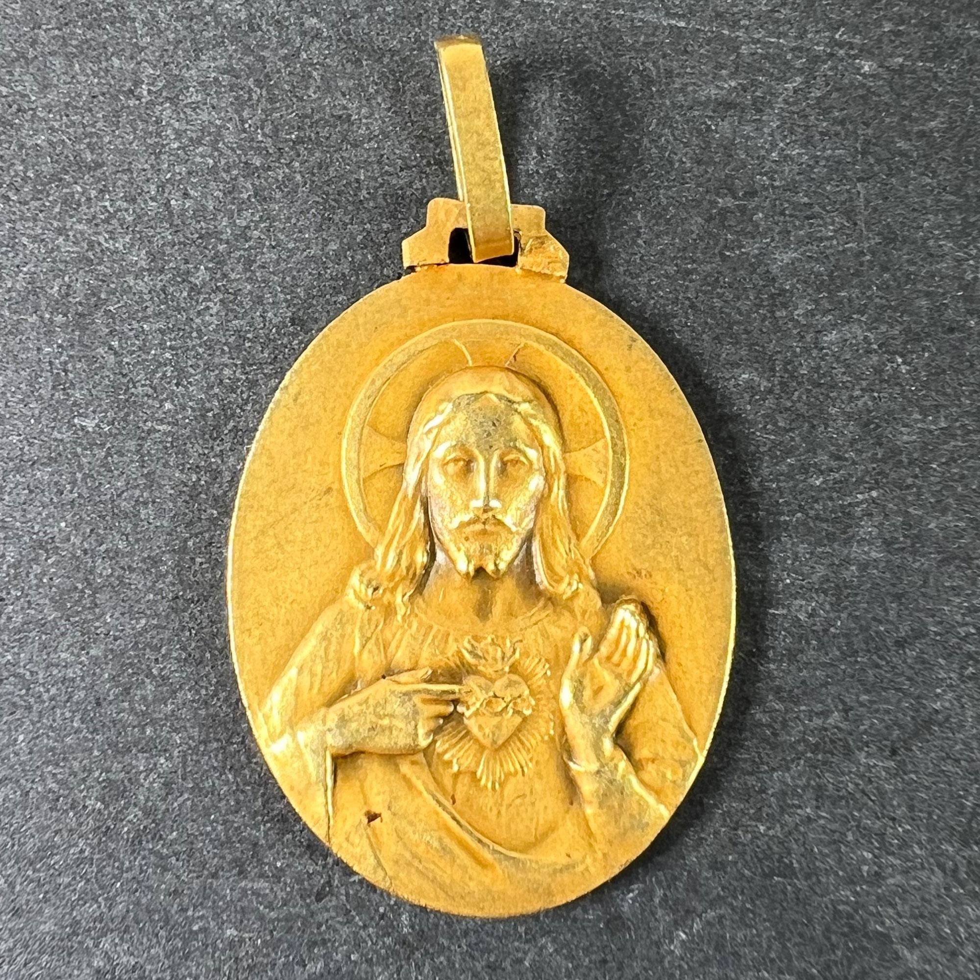 Ein französischer Anhänger aus 18 Karat (18K) Gelbgold in Form einer ovalen Medaille mit einem Relief von Jesus Christus mit dem Heiligsten Herzen auf der einen Seite; auf der anderen Seite die Jungfrau Maria als Madonna mit Kind auf einem Thron im