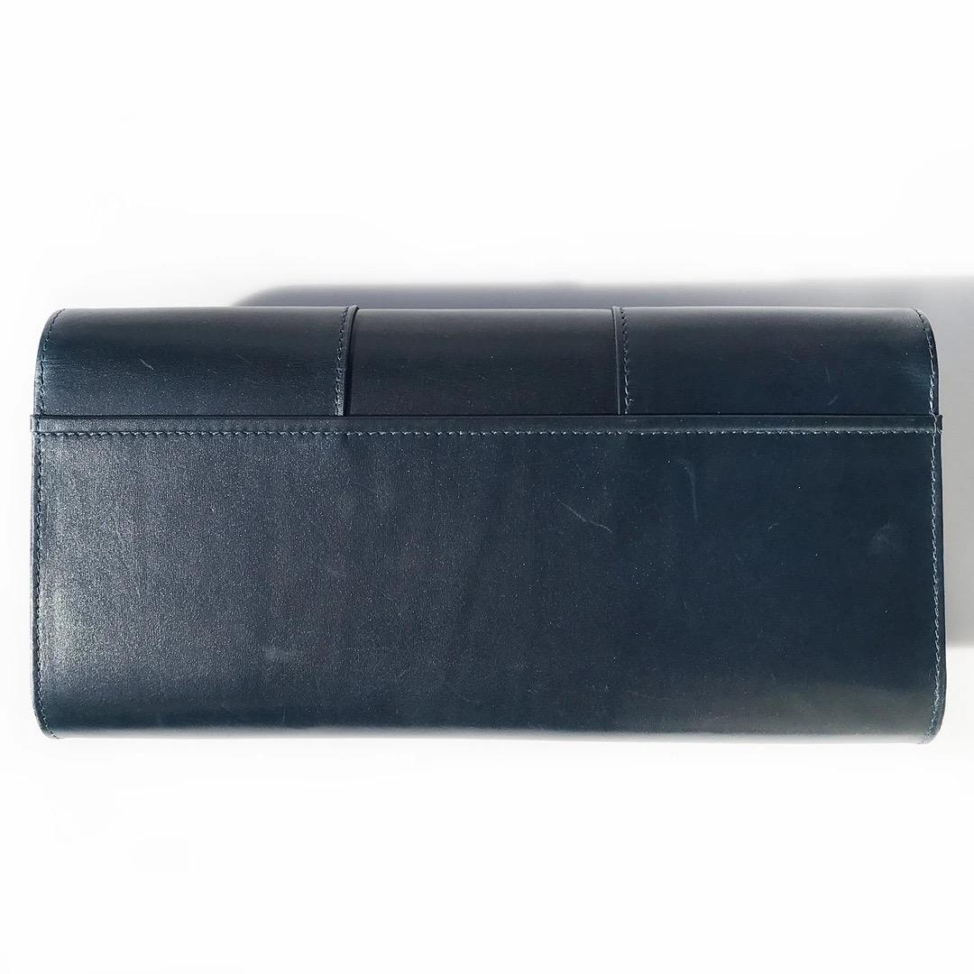 Perrin Le Cabriolet Clutch 
Navy Blue 
Leather 
Structured Clutch 
Glove detail 
Gold-tone hardware 
Interior open pocket 
Magnetic closure 
Envelope style clutch 
Excellent condition; Preloved with no visible signs of wear or use throughout handbag