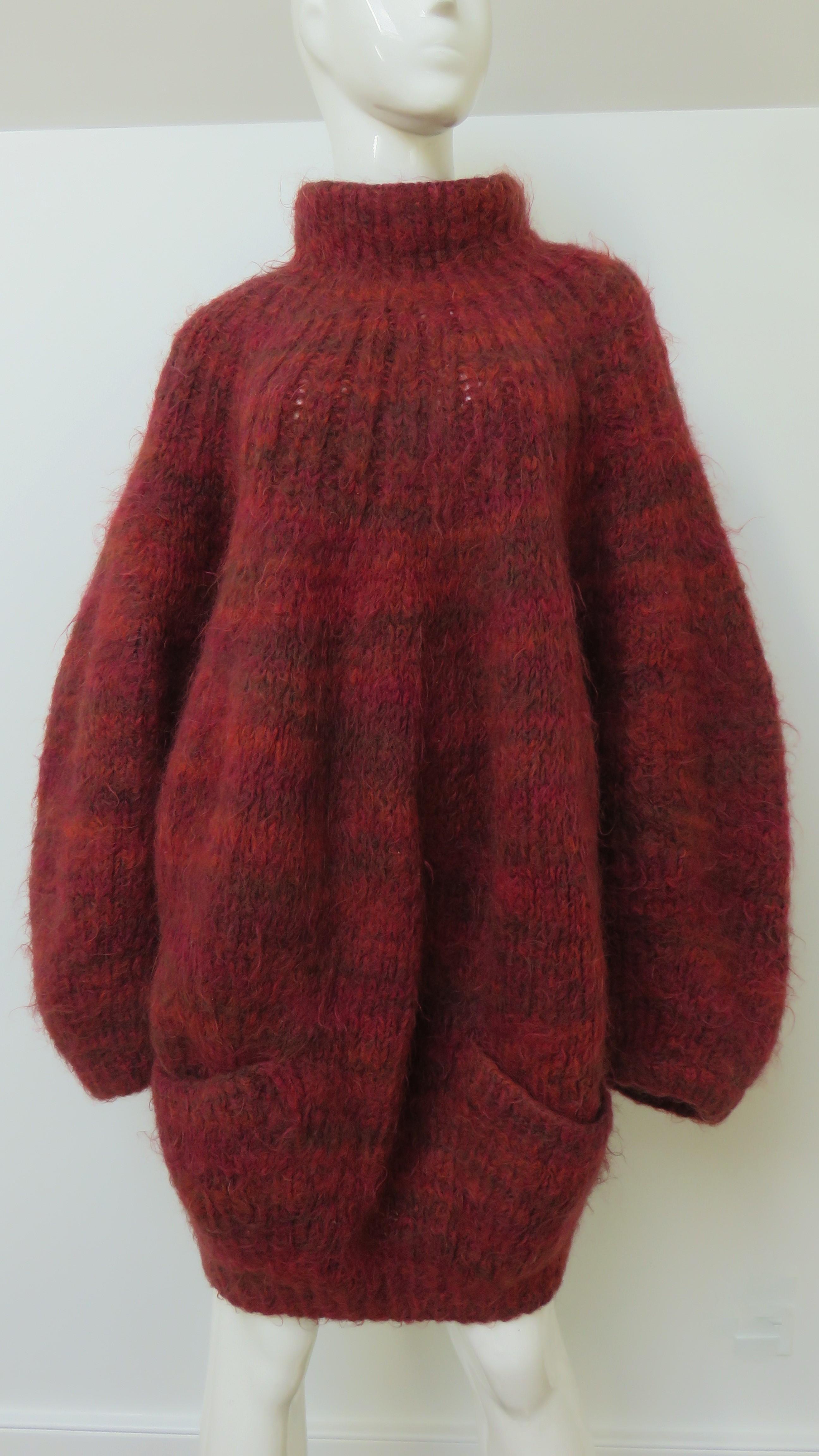 A fabulous wool knit oversized sweater in shades of burgundy from the great but all too brief career of American designer Perry Ellis. It has a standup collar, front patch pockets and ribbing at the hem.
Marked One Size.