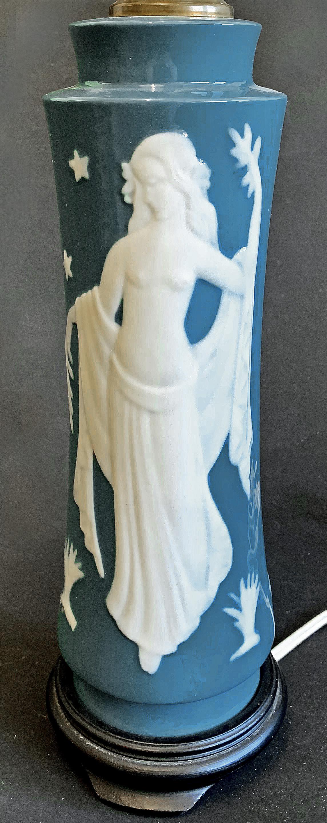 Magnifiquement sculptée et façonnée en porcelaine, dans des tons de blanc et de bleu ardoise, cette rare et belle lampe de table représente Perséphone, déesse du printemps, en bas-relief. La lampe a été fabriquée par la célèbre entreprise de