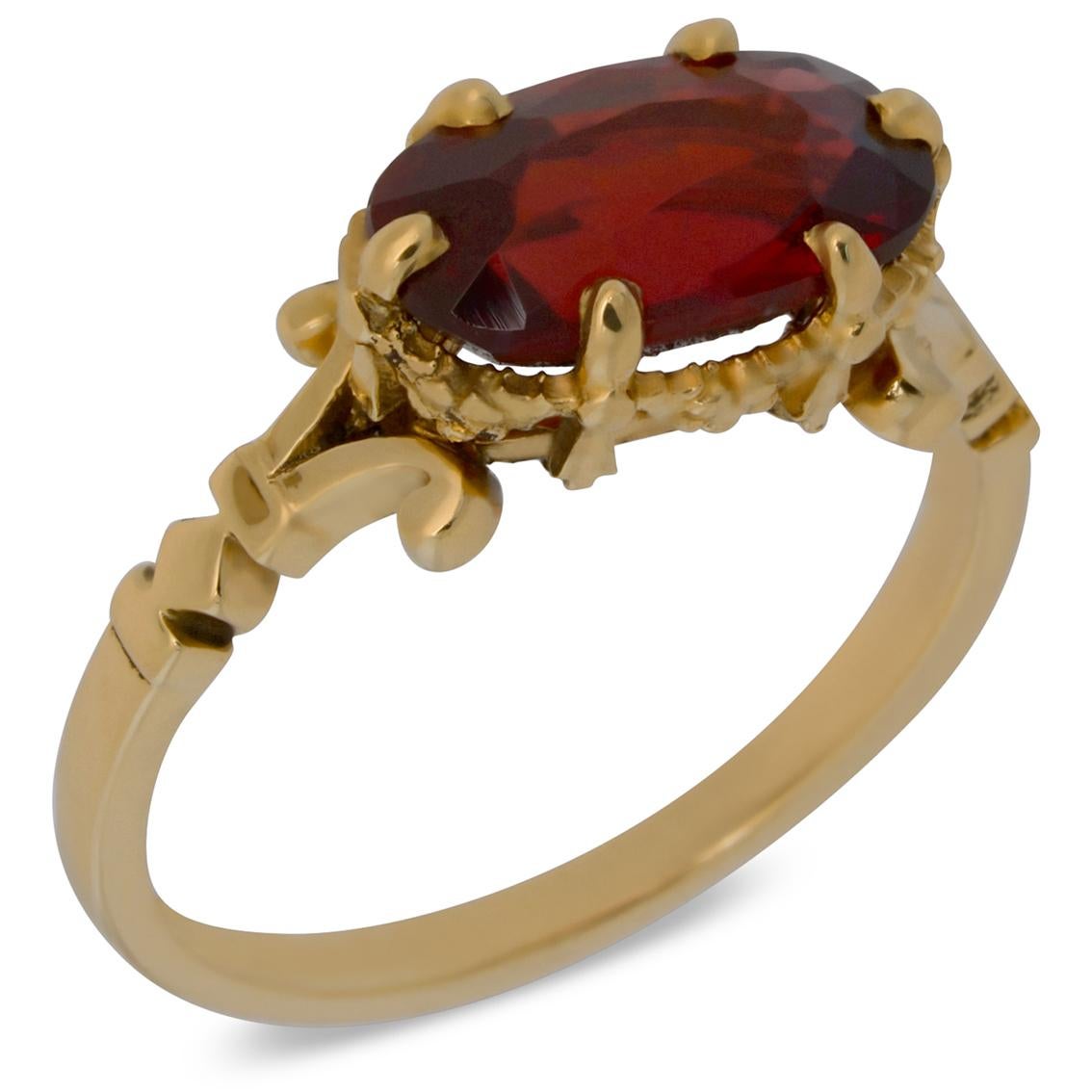 Exquisitely handcrafted in 9kt yellow gold this otherworldly ring features a gorgeous 11mm (L) x 6.5mm (W) x 4mm (D) oval cut garnet aloft a signature William Llewellyn Griffiths split shank and garland setting decorated with fine floral details.