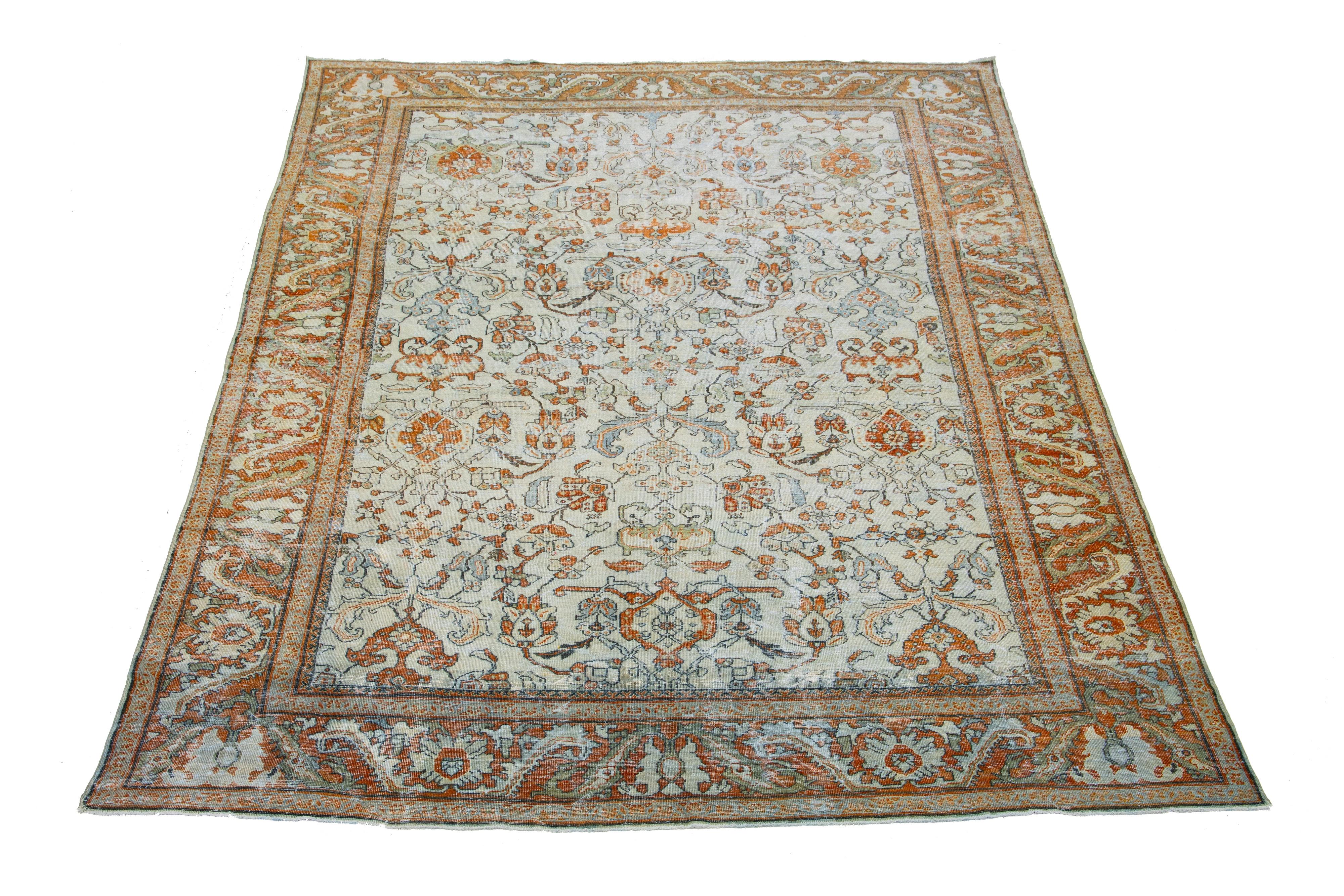 Beautiful antique Persian Mahal hand-knotted wool rug with a beige field. This piece has an orange-designed frame with gray accents in a gorgeous all-over floral design.

This rug measures 10'8