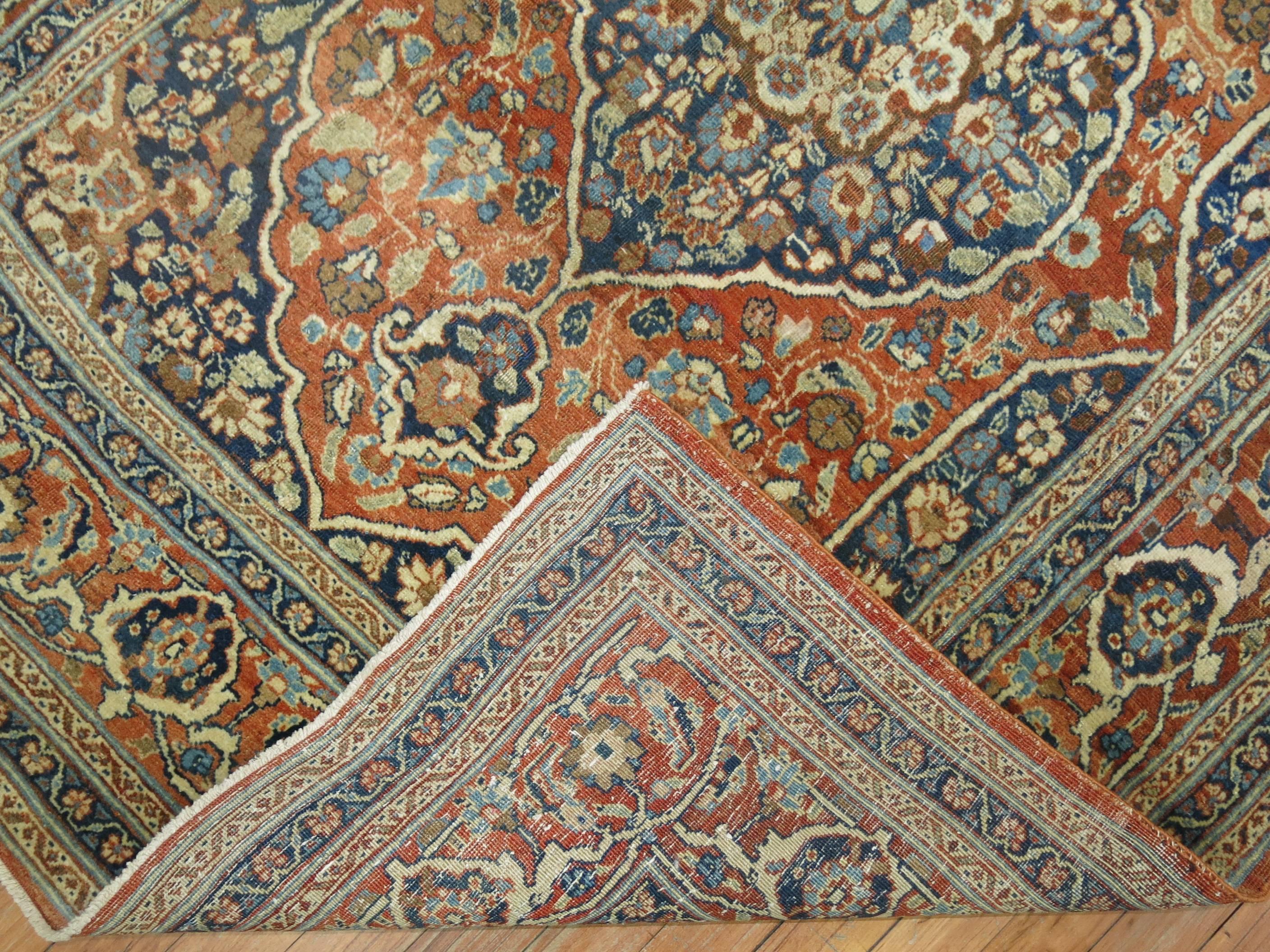 An authentic handmade Persian Tabriz rug in oranges and blues with Classic medallion and border.