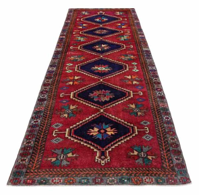 Découvrez l'élégance d'un tapis persan Azerbaïdjan avec un chemin de table datant de 1910. Conçu avec de la laine et du VertBleu marineOrangeRouge, ce design exclusif est parfait pour mettre en valeur votre espace.