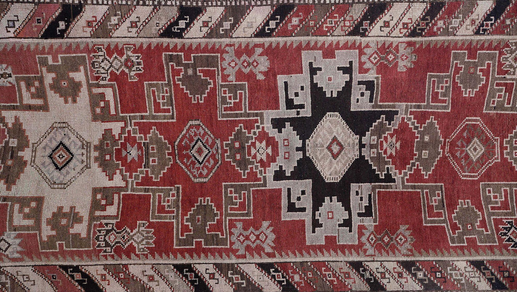 Entdecken Sie die Eleganz des persischen Aserbaidschans mit dem Läufer von CIRCA 1910. Dieses exklusive Design aus Wolle und BlackBrownIvoryRed ist perfekt, um Ihren Raum zu verschönern.