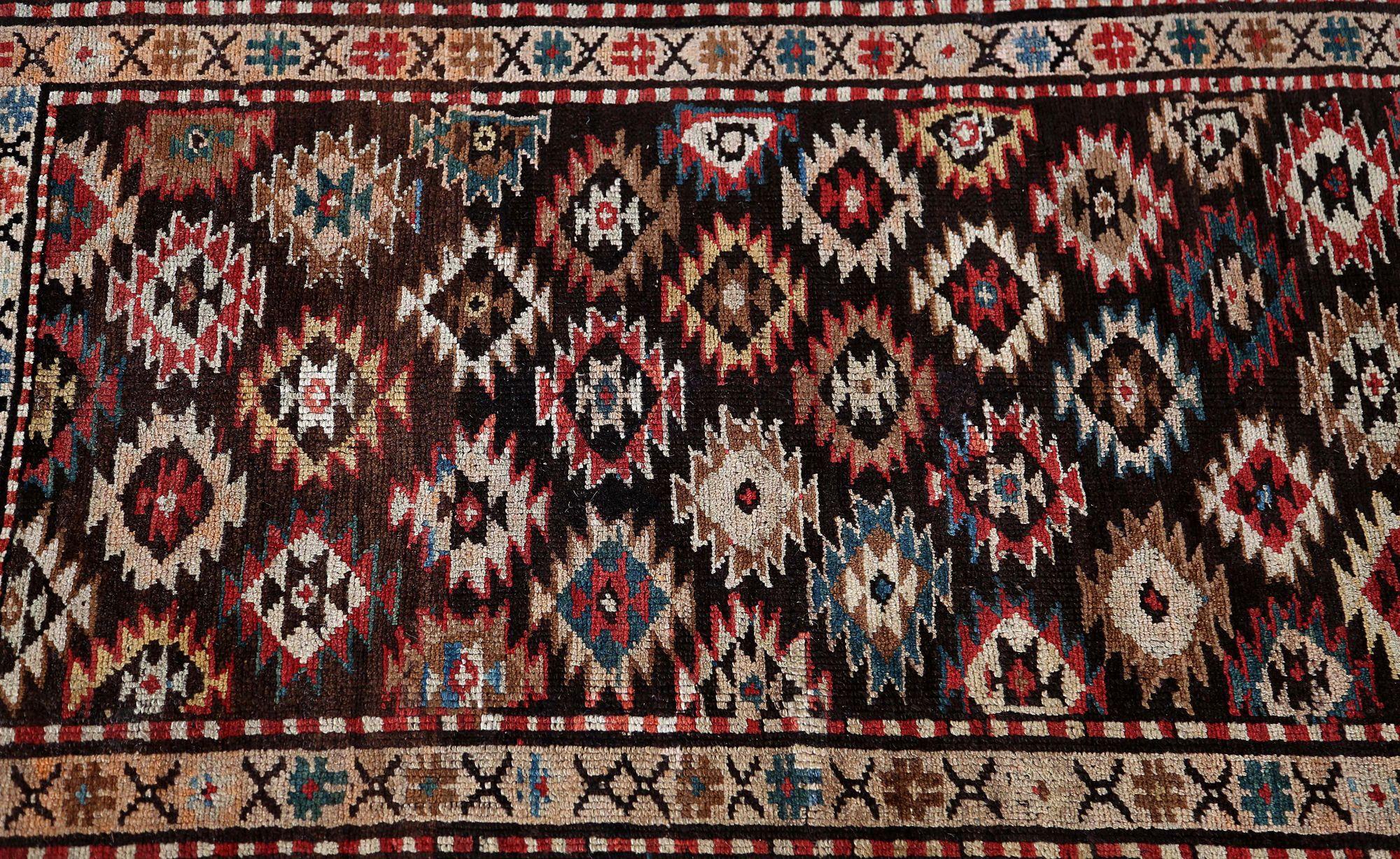 Entdecken Sie die Eleganz des persischen Aserbaidschans mit dem Läufer von CIRCA 1910. Dieses exklusive Design aus Wolle und BlauBraunElfenbeinRotGelb ist perfekt, um Ihren Raum zu verschönern.