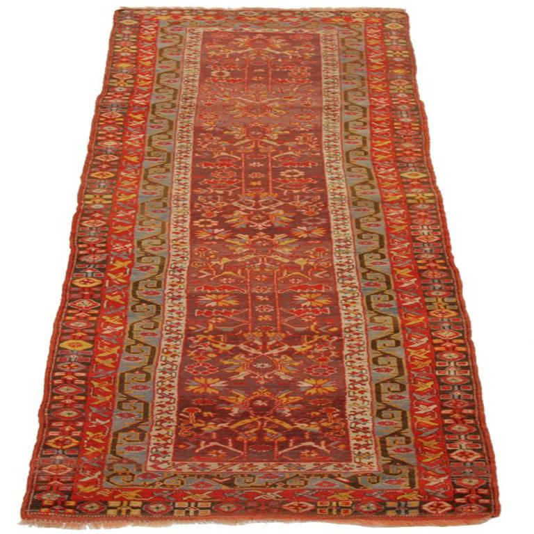 Entdecken Sie die Eleganz des persischen Aserbaidschans mit dem Läufer von CIRCA 1910. Dieses exklusive Design aus Wolle und BlauGrünRotGelb ist perfekt, um Ihren Raum zu verschönern.