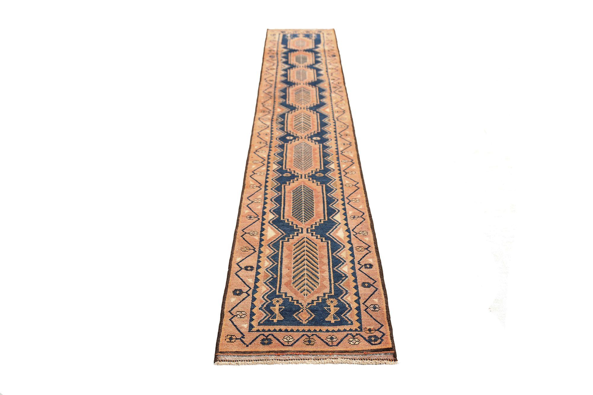Entdecken Sie die Eleganz des persischen Aserbaidschans mit dem Läufer von CIRCA 1910. Dieses exklusive Design in den Farben Wolle und BraunMarineblauRosa ist die perfekte Ergänzung für Ihren Raum.