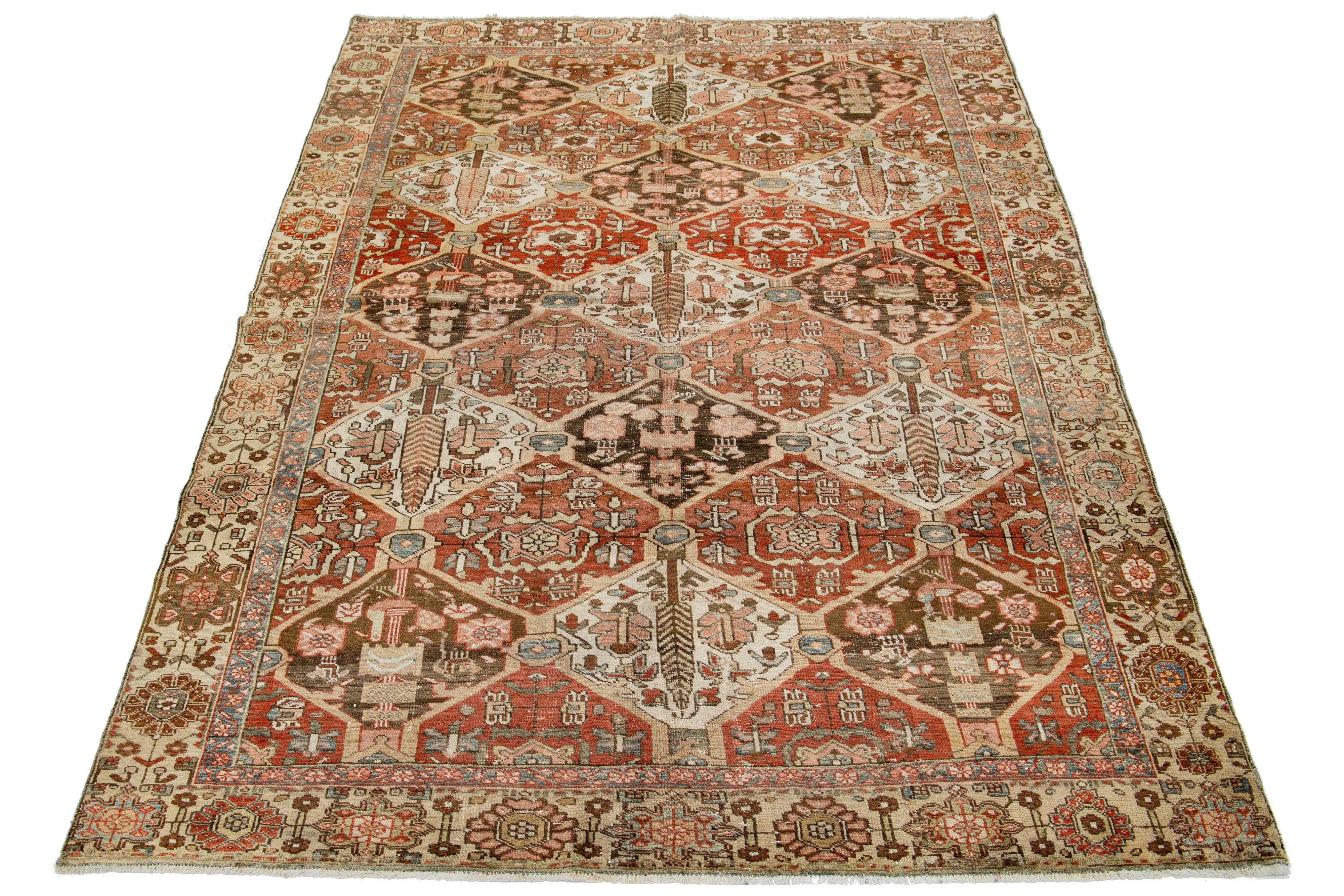 This beautiful antique Bakhtiari hand-knotted wool rug features a field of red-rust color. It showcases a classic Persian design with blue, beige, and peach floral colors.

This rug measures 6'5