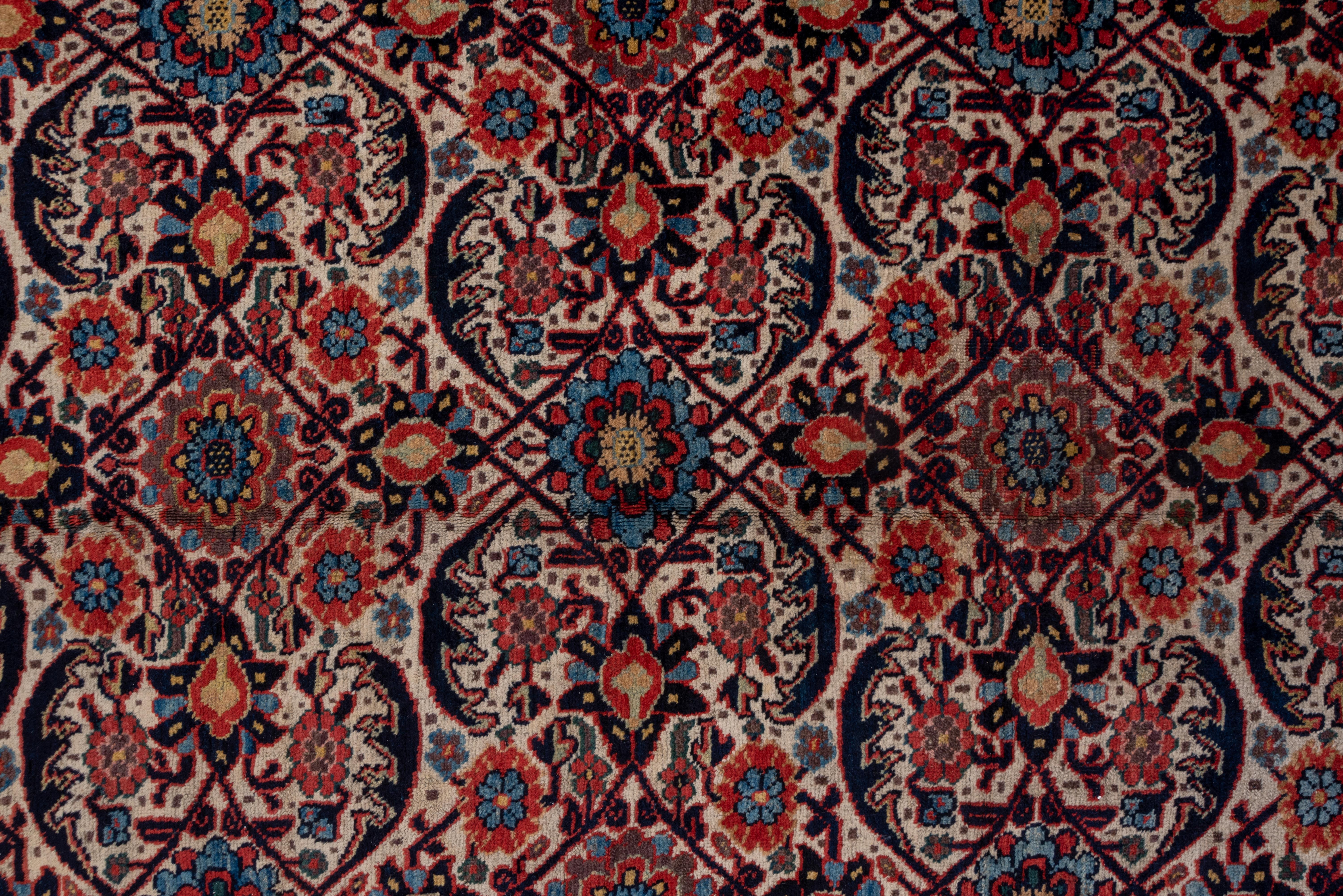 This otherwise top condition west Persian Kurdish town carpet has magnificent color with a particularly Kurdish variant on the Herati pattern on an ecru ground accented in navy, red, pale blue, green and straw. The main border of this extremely