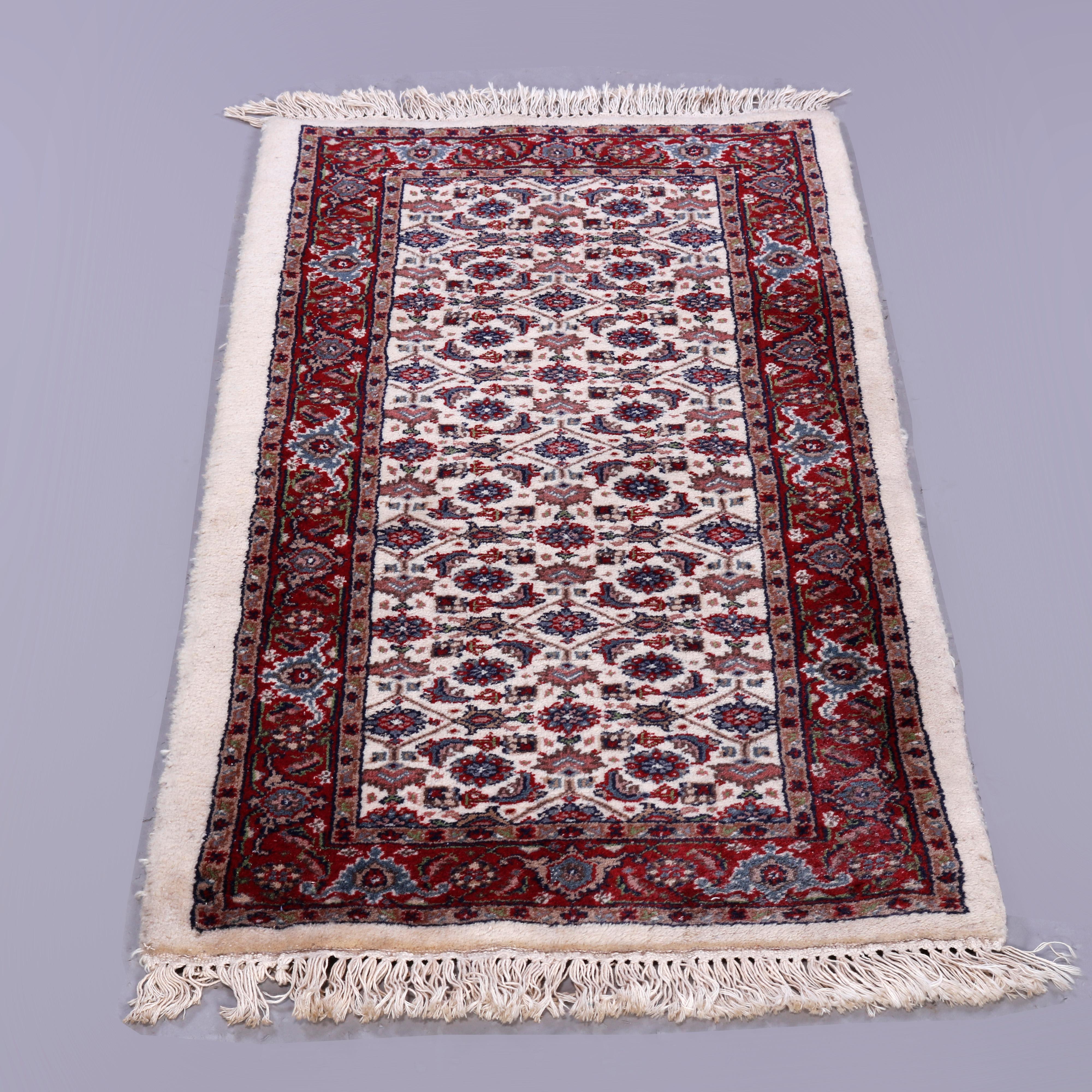 A Persian Bidjar oriental rug offers repeating design of stylized floral and foliate elements on cream ground with complementing red border, circa 1950

Measures - 53''H x 25''W x 1''D.

Catalogue Note: Ask about DISCOUNTED DELIVERY RATES available