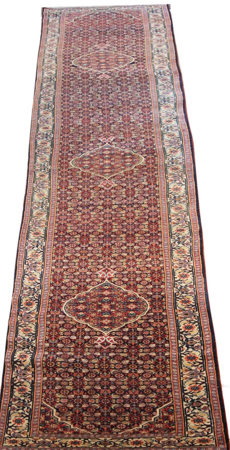 Découvrez l'élégance du tapis de course persan Bijar, datant de 1910. Conçu avec de la laine et de l'ivoire bleu marine, ce design exclusif est parfait pour mettre en valeur votre espace.