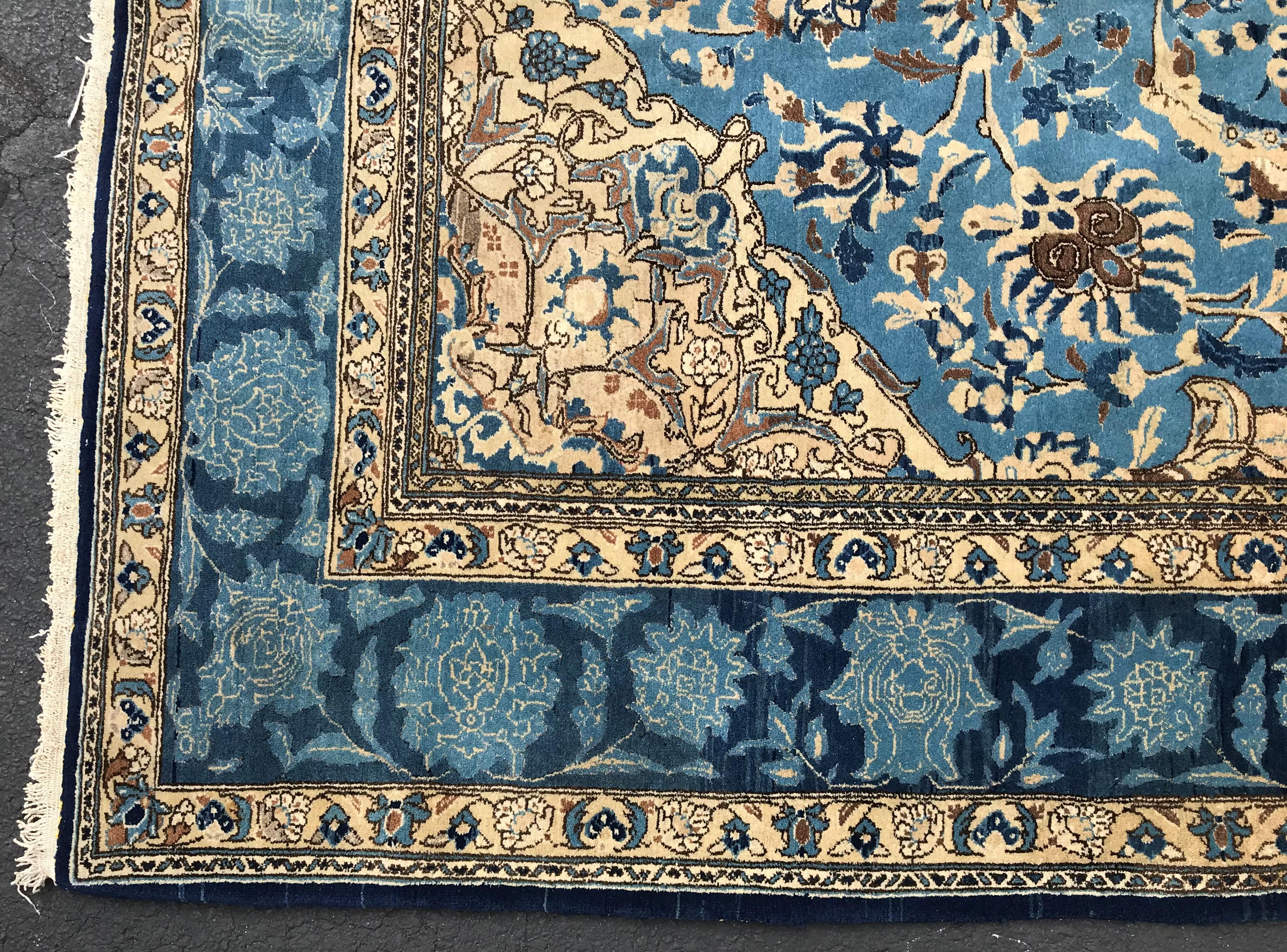 A beautiful Persian room size wool and silk weave rug with central round cream medallion on a light blue field with a navy and light blue foliate decorated border using vegetable dyes and a tight master weave. This rug is in very good condition,