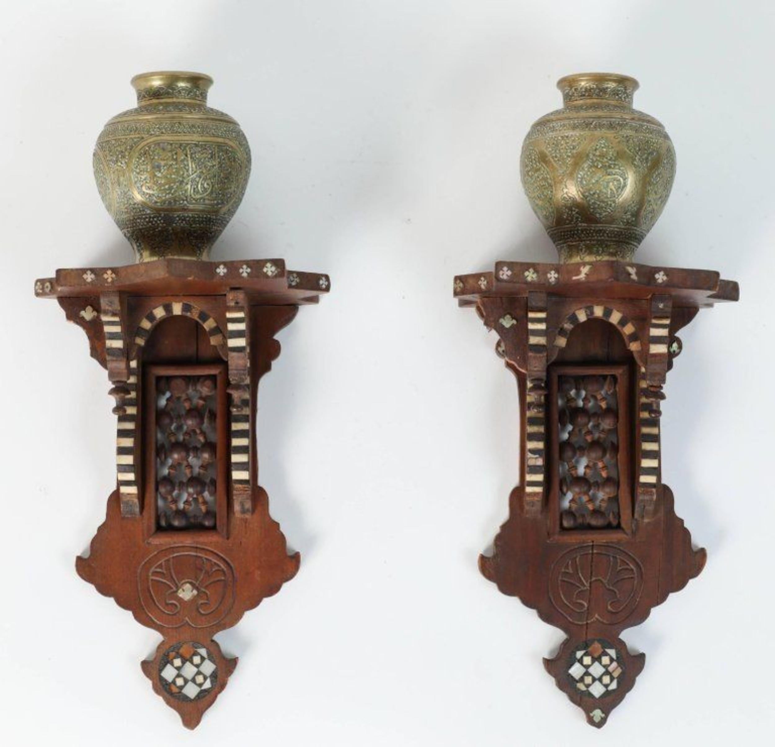 Beautiful pair of Persian engraved Ghalam-zani brass vases on Middle Eastern wooden wall decorative brackets.


The small brass vases are finely hand-chased with elaborate designs and presented on hand crafted wooden brackets inlaid with mother