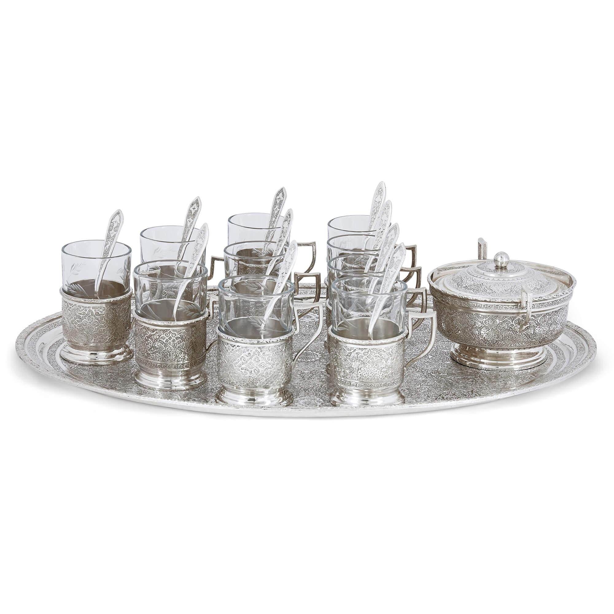 Persian engraved glass and silver part-drinks service 
Persian, 20th Century
Tray: Height 2cm, width 43.5cm, depth 29.5cm
Cups: Height 8cm, width 7.5cm, depth 5cm

Showcasing sensational engraving of Persian design, this glassware set is comprised