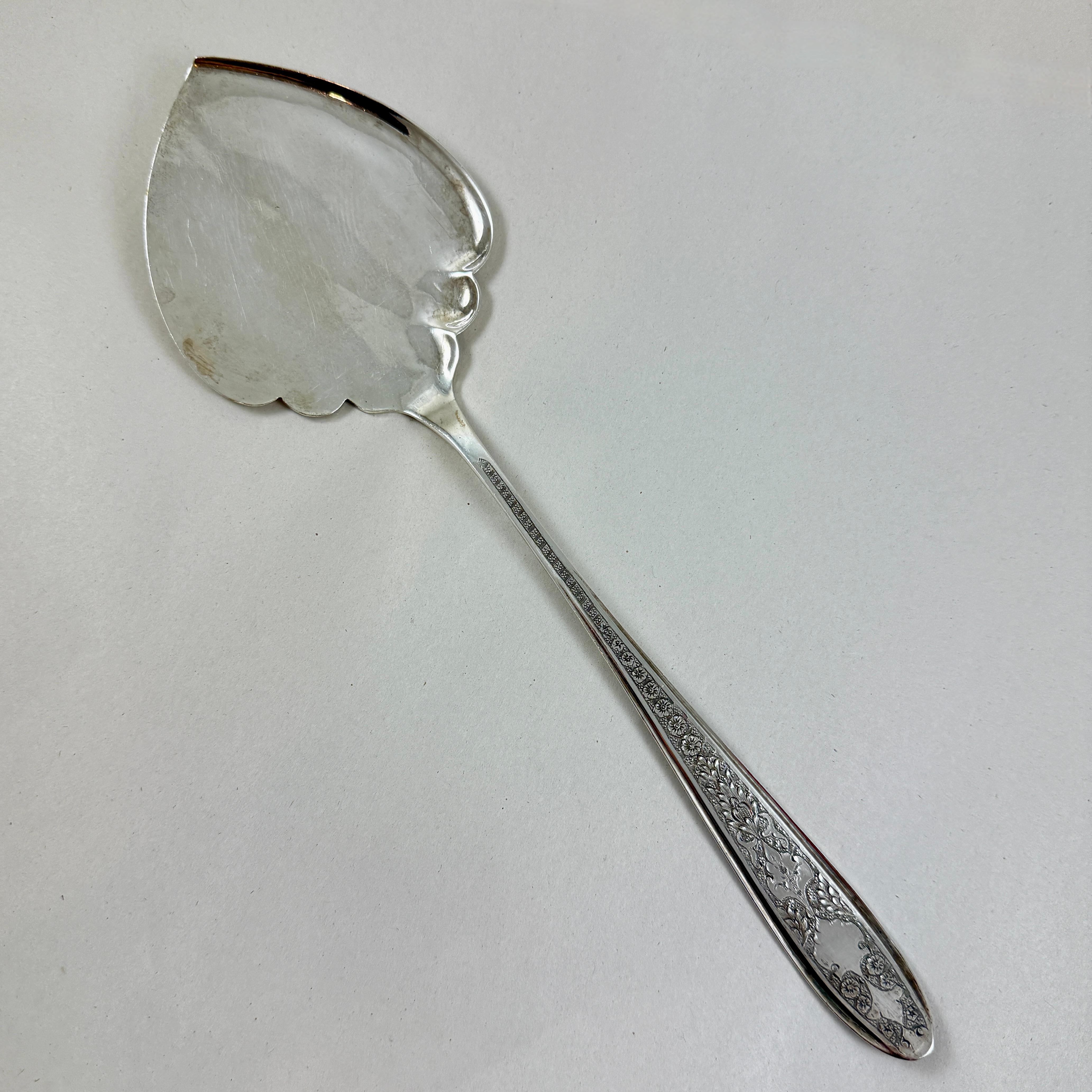 Dalla Persia, un pesante server da pasticceria in argento fatto a mano, risalente all'inizio del XX secolo.

Il server è un pezzo grande e imponente con una purezza di 875.

Il manico lungo presenta un motivo floreale ornato e inciso, mentre la