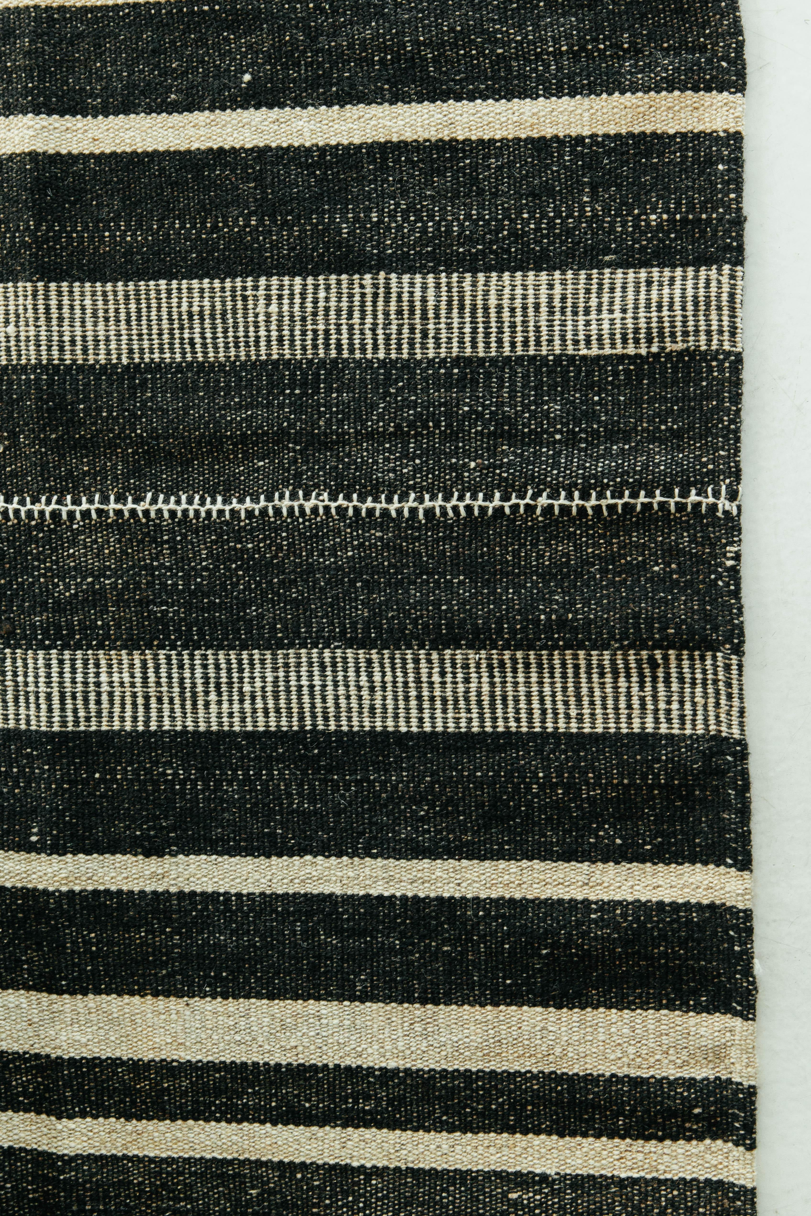 Dieser persische Jejim-Kilim ist ein gebändertes Flachgewebe mit abwechselnd schwarzen und elfenbeinfarbenen Streifen in verschiedenen Größen und Ausführungen. Persische Flachgewebe bestehen aus der besten Wolle und werden ausnahmsweise gewebt, um