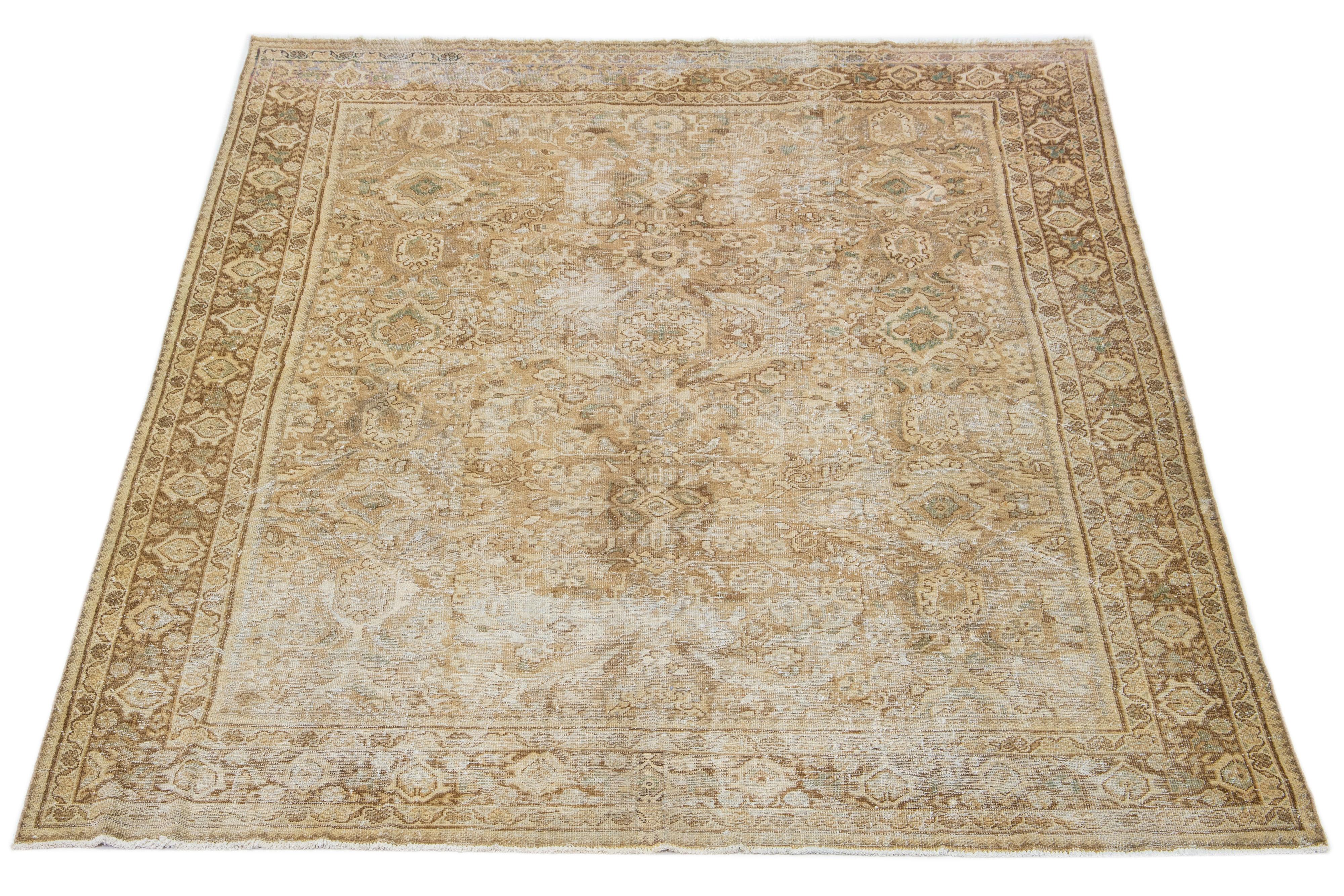 Beautiful Vintage Mahal hand-knotted wool rug with a beige color field. This Persian rug has green and brown hues throughout the floral motif.

This rug measures 9'7