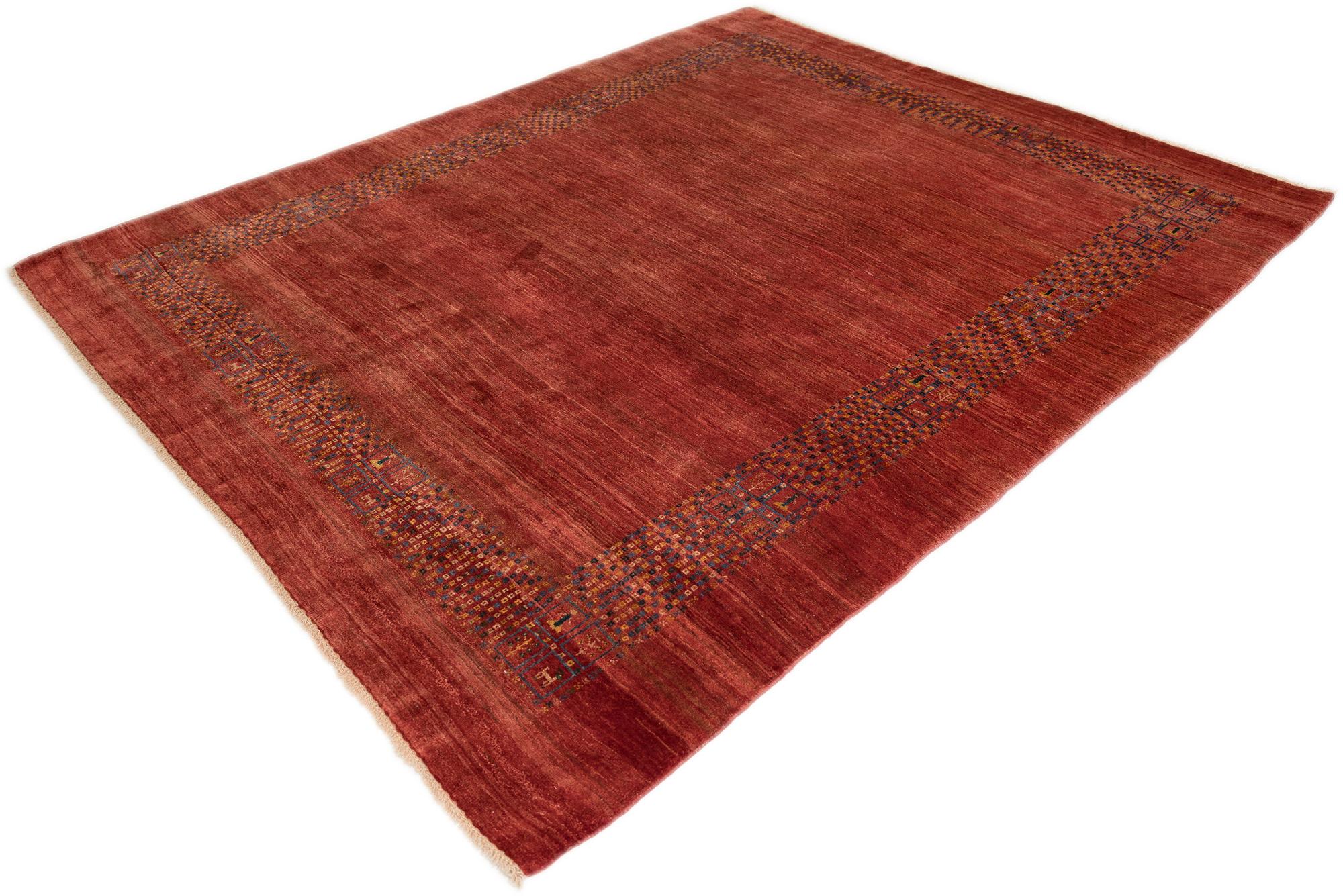 This Persian wool Gabbeh rug features a warm red field with a subtle geometric border. Its minimalist design and natural color variations make it versatile for both modern and traditional interiors.
Origin: Persian
Material: Wool
Technique: