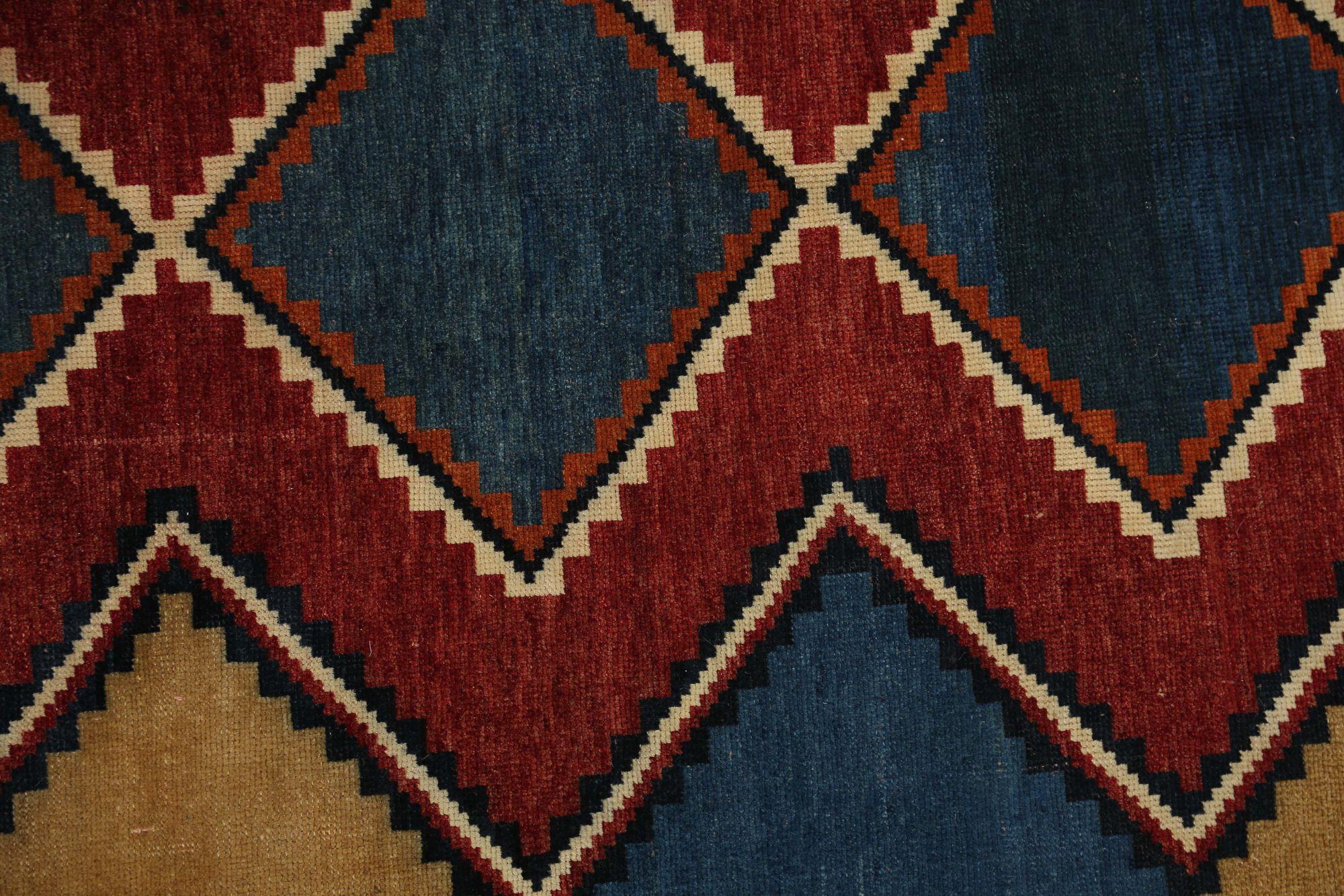 Entdecken Sie die Eleganz der persischen Gabbeh-Teppiche aus der Zeit um 1910. Dieses exklusive Design aus Wolle und Blau-Elfenbein-Rot-Gelb ist perfekt, um Ihren Raum zu verschönern.