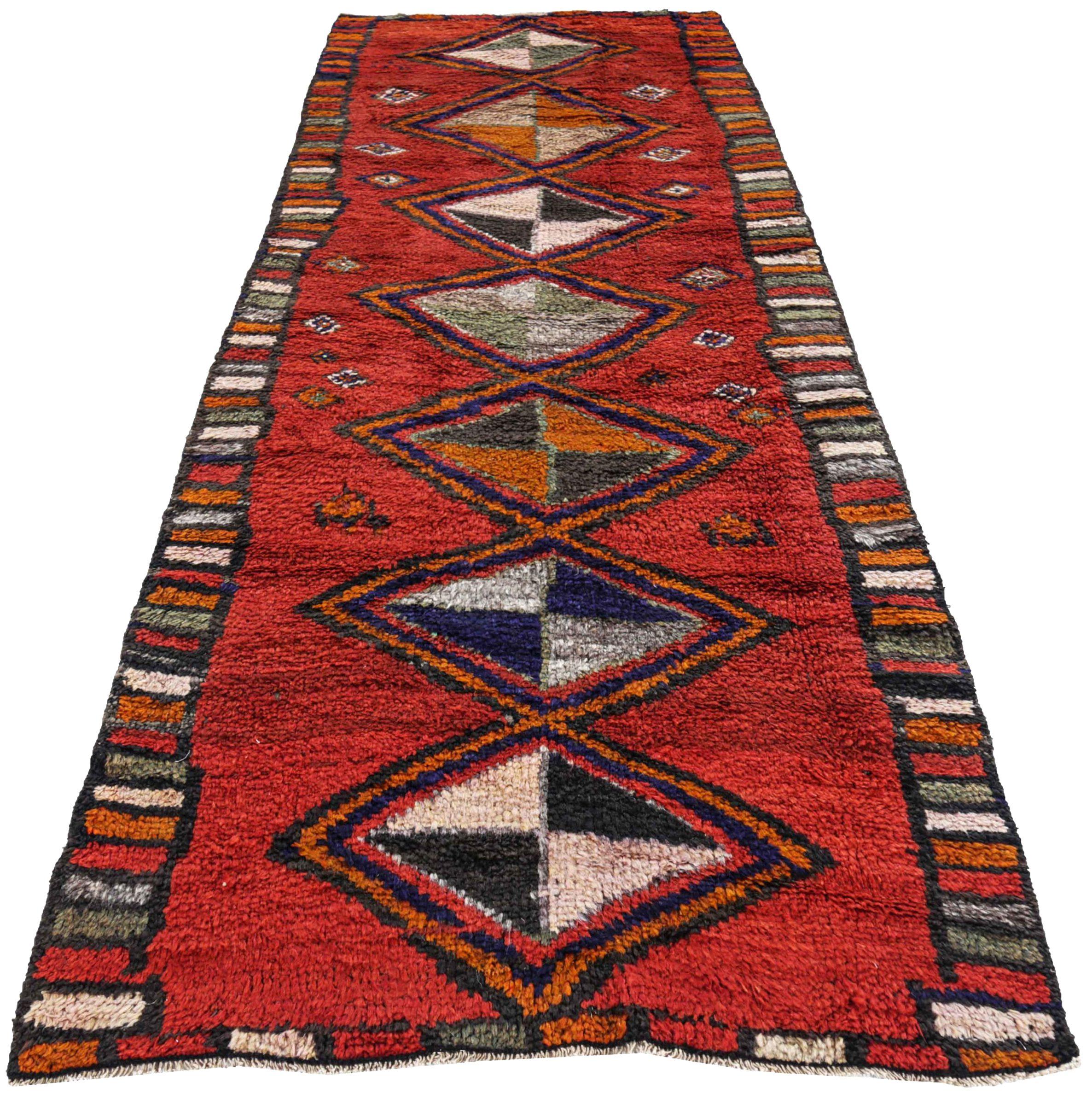 Entdecken Sie die Eleganz des persischen Gabbeh-Teppichs mit Läufer um 1910. Dieses exklusive Design aus Wolle und BlauGrünOrangeRot ist perfekt, um Ihren Raum zu verschönern.