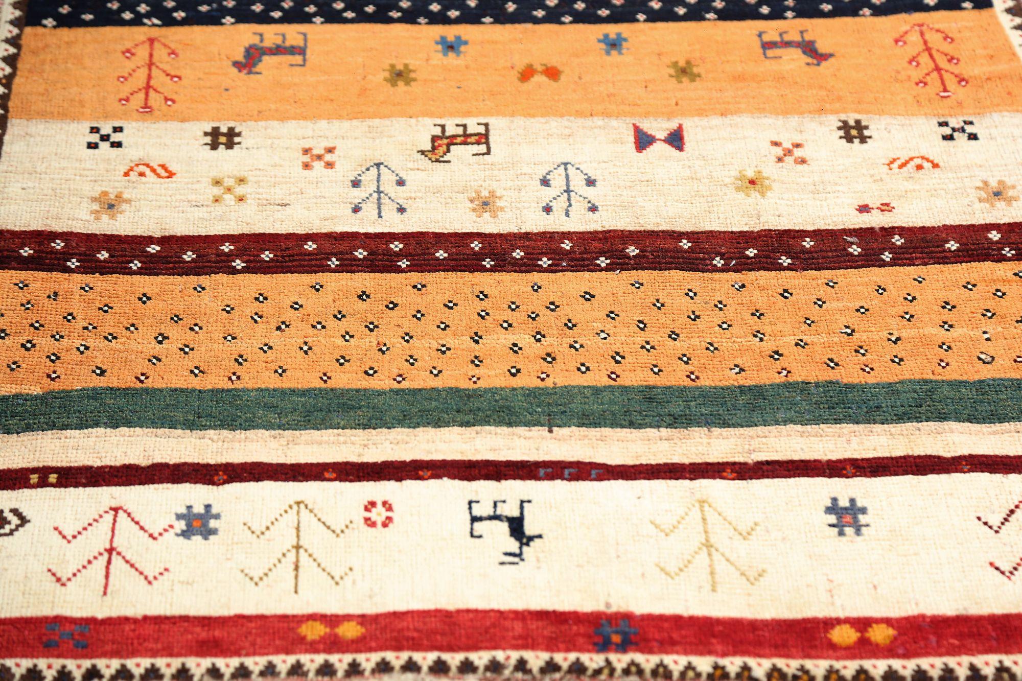 Entdecken Sie die Eleganz des persischen Gabbeh mit dem kleinen Teppich CIRCA 1910. Dieses exklusive Design aus Wolle und ElfenbeinOrange ist perfekt, um Ihren Raum zu verschönern.