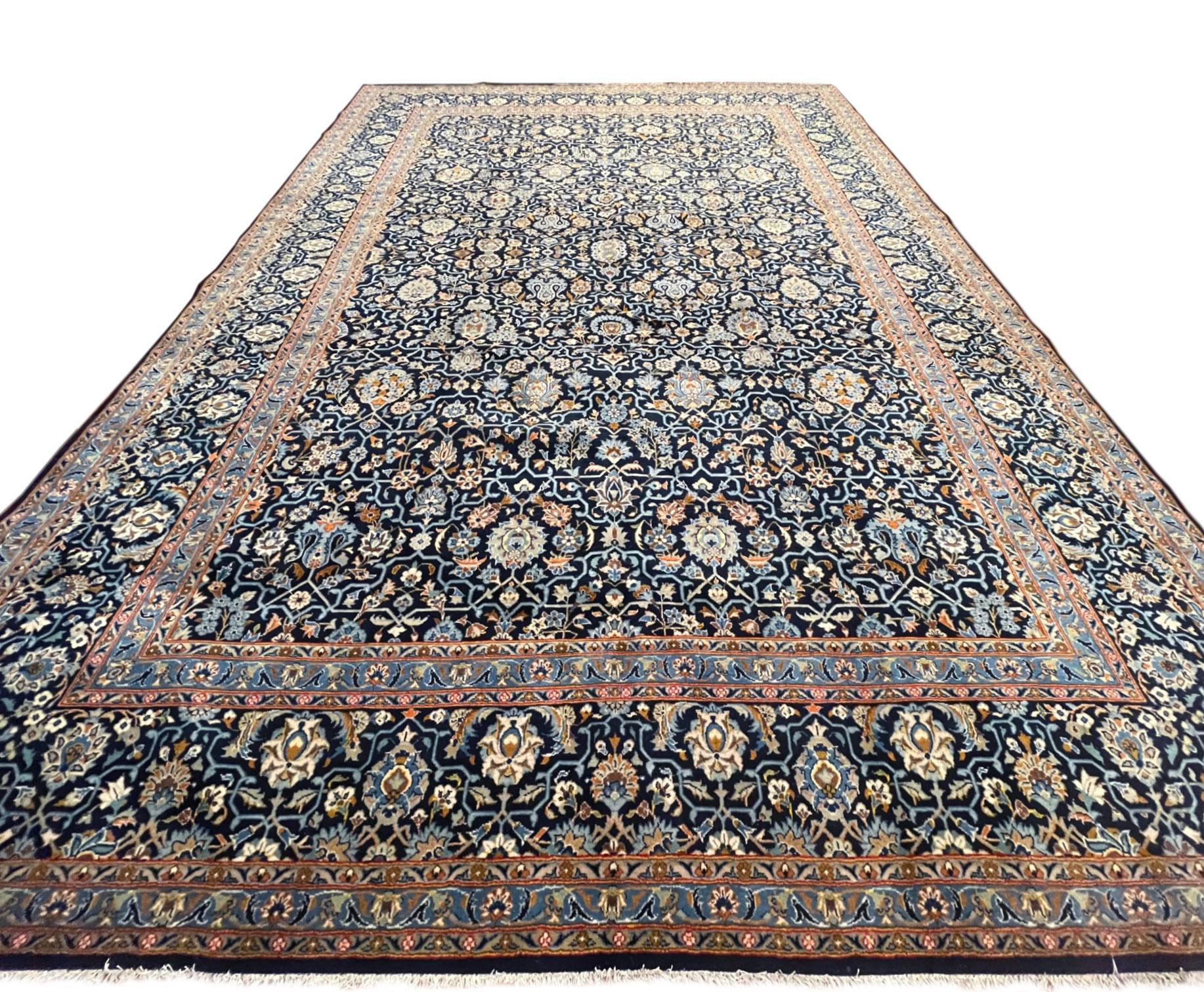 Questo tappeto fatto a mano proviene da Kashan, una delle classificazioni tradizionali dei tappeti persiani. I tessitori di Kashan producono tappeti di alta qualità con elevati standard di design e tecnica. Questo pezzo ha un vello di lana e una