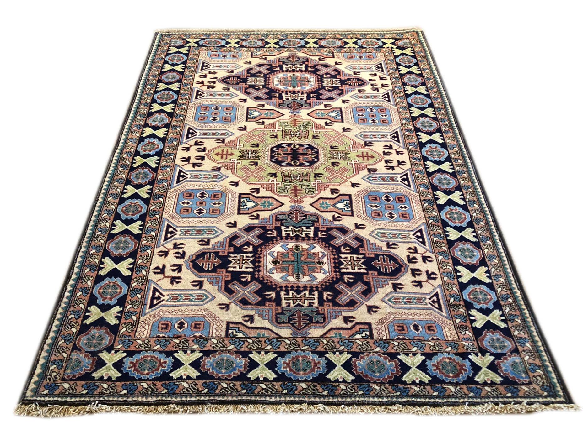 This rug is knotted in the province of Azarbayjan in north west of Iran. The design is geometric with repeated medallion. The pile is wool with cotton foundation. The base color is cream and the border is blue. The design and color combination can