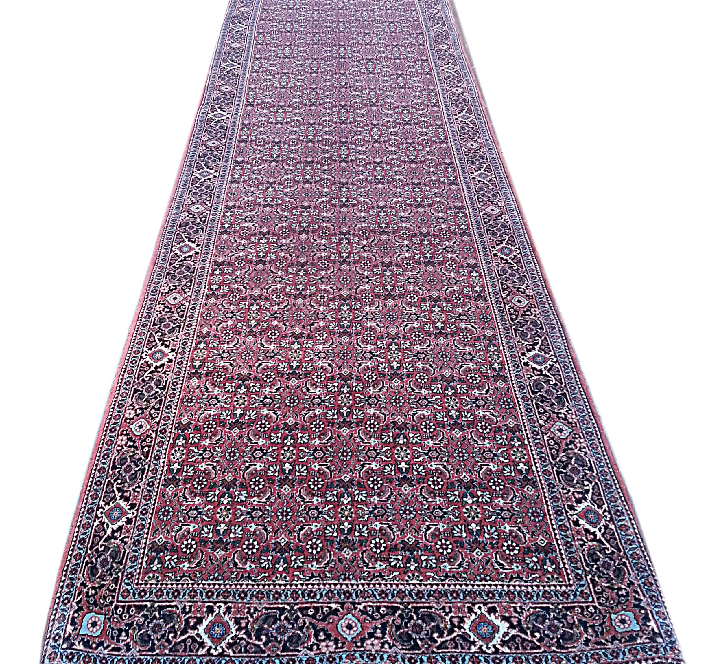This Authentic beautiful oversized Bijar runner has wool pile and cotton foundation. The rug is all-over floral which is called Herati design. The color combination in this piece is red, cream and blue. Bijar rugs are well known for their